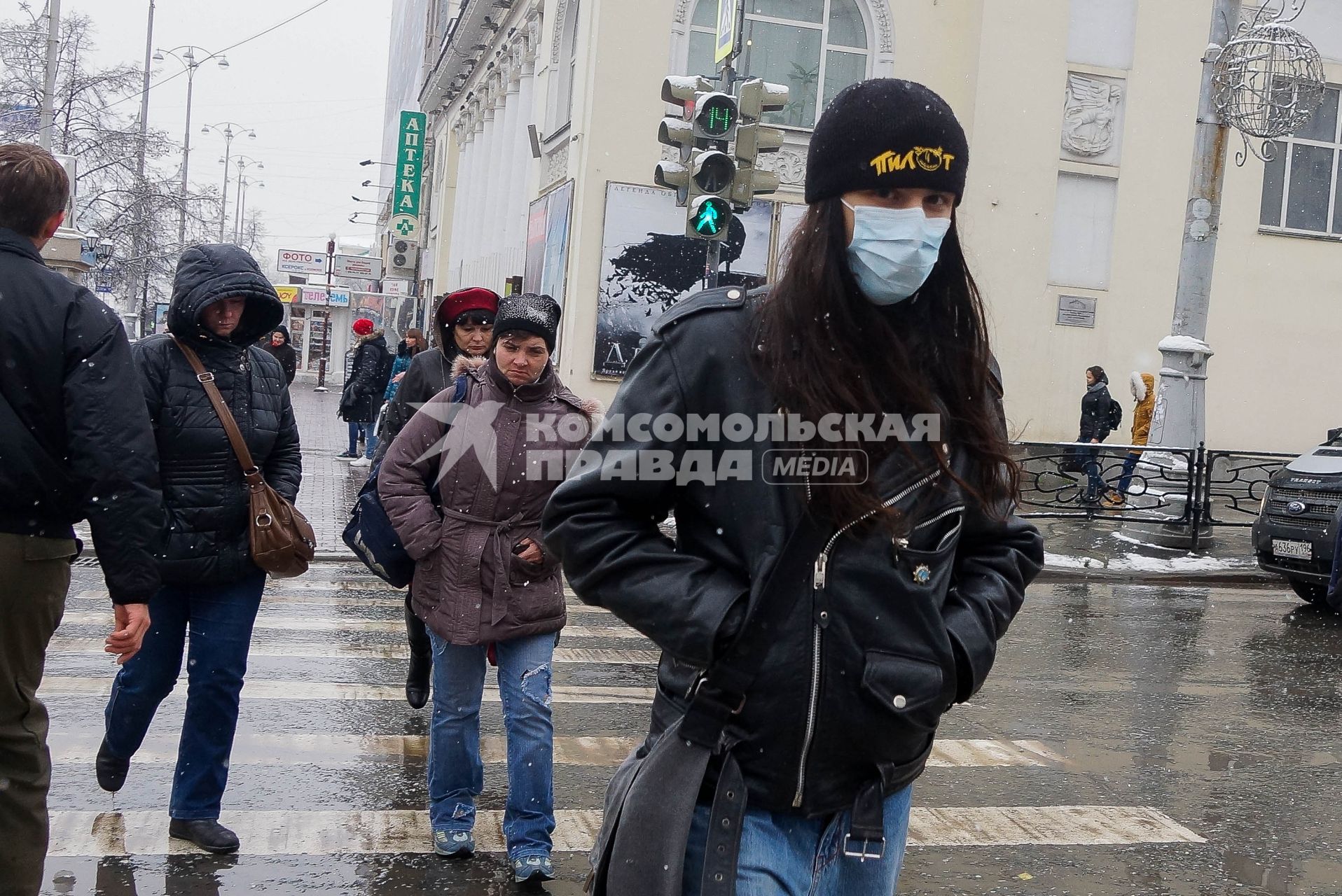 парень с медицинской маской на лице во время снегопада