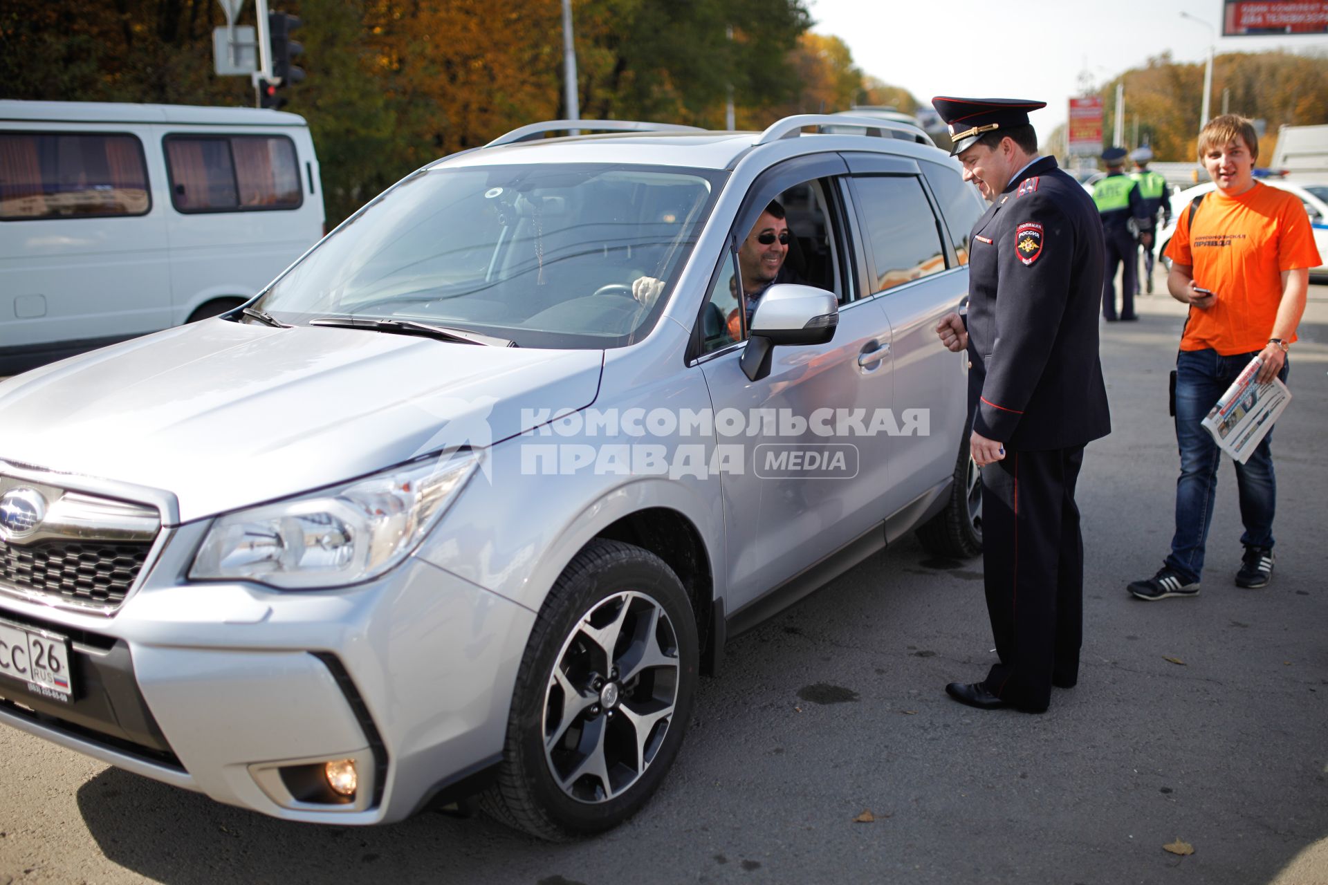 Совместная акция `Комсомольской правды` и ГИБДД `Улыбнись и пристегнись`. На снимке: начальник УГИБДД ГУ МВД России по Ставропольскому краю подполковник полиции Алексей Сафонов разговаривает с водителем.