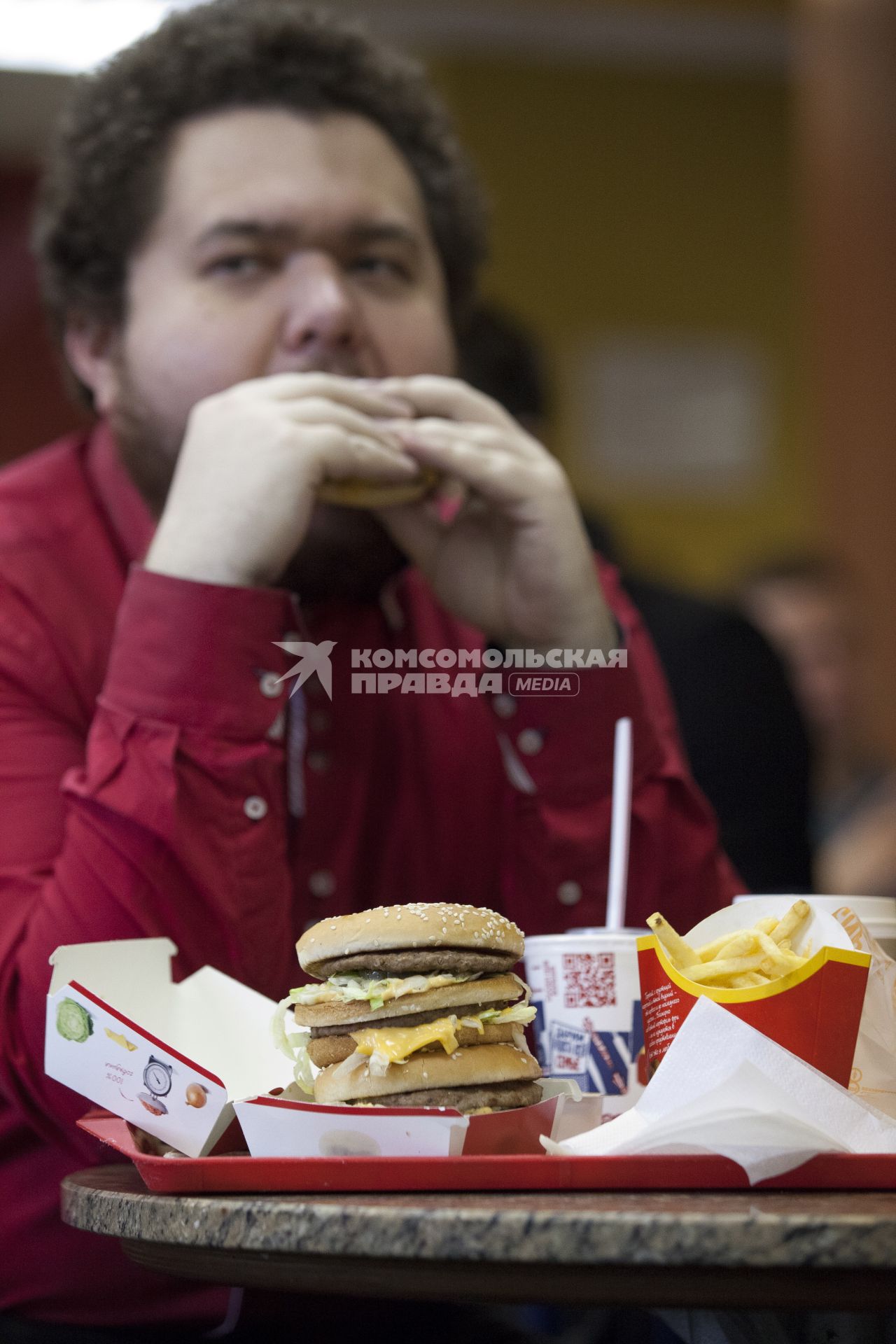 Человек ест гамбургер.