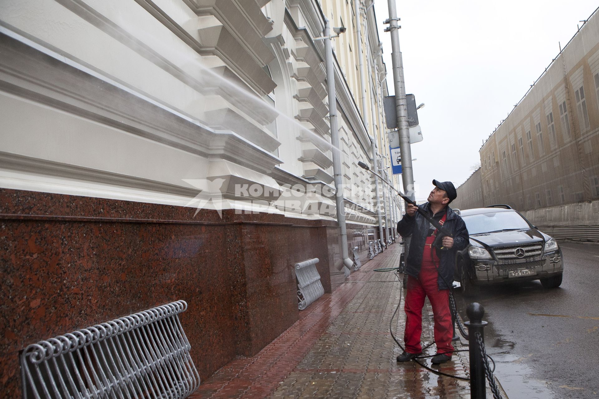 Гастарбайтер моет здание.