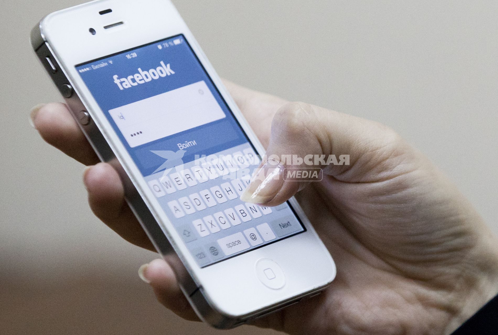 Человек использует мобильное устройство для входа в социальную сеть facebook.
