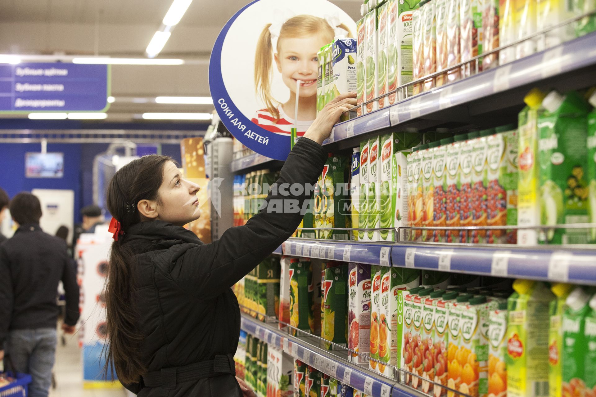 Девушка делает покупки в гипермаркете.