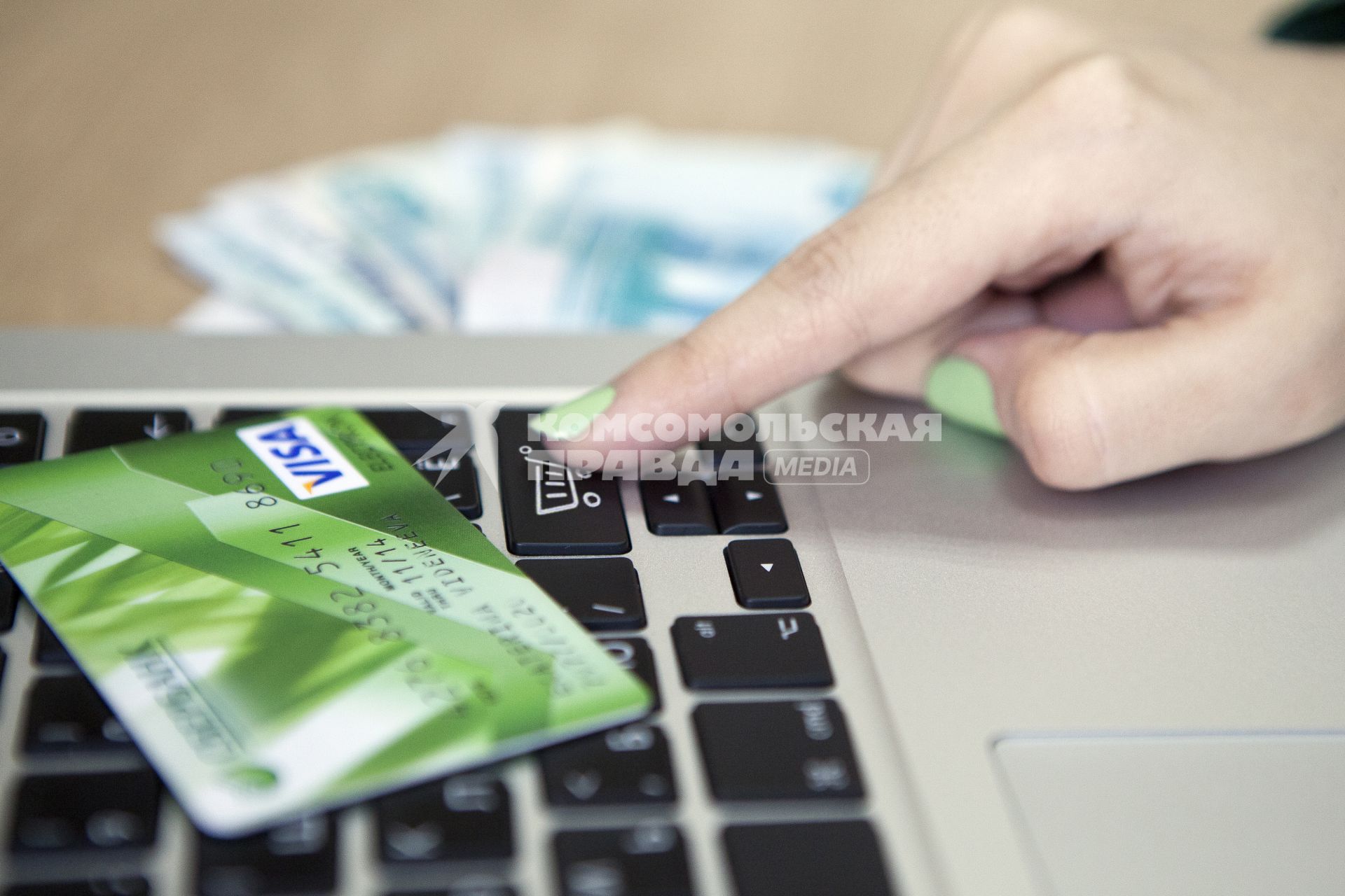 Человек совершает покупку через интернет используя кредитную карту