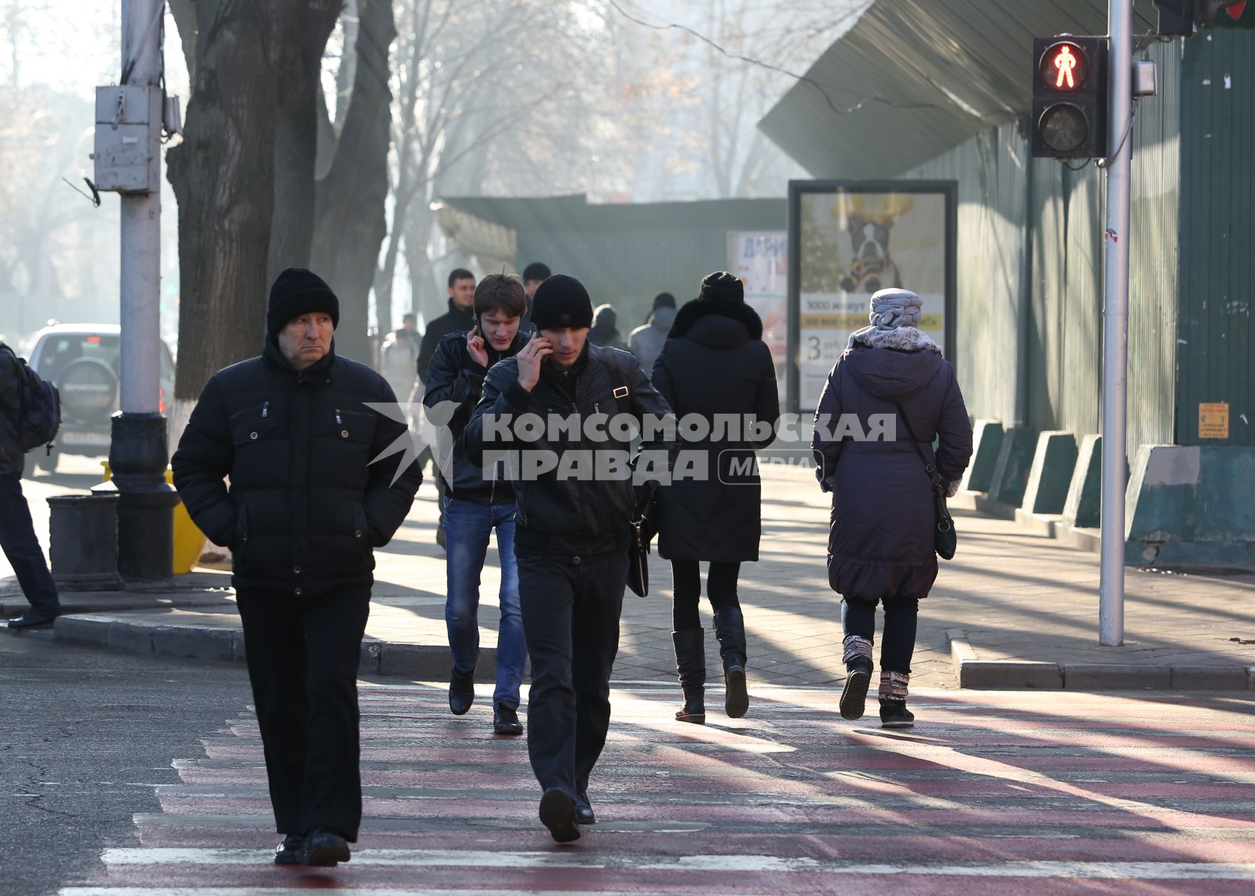 Пешеходы увлеклись разговорами по телефону и нарушают ПДД переходя проезжую часть на красный сигнал светофора