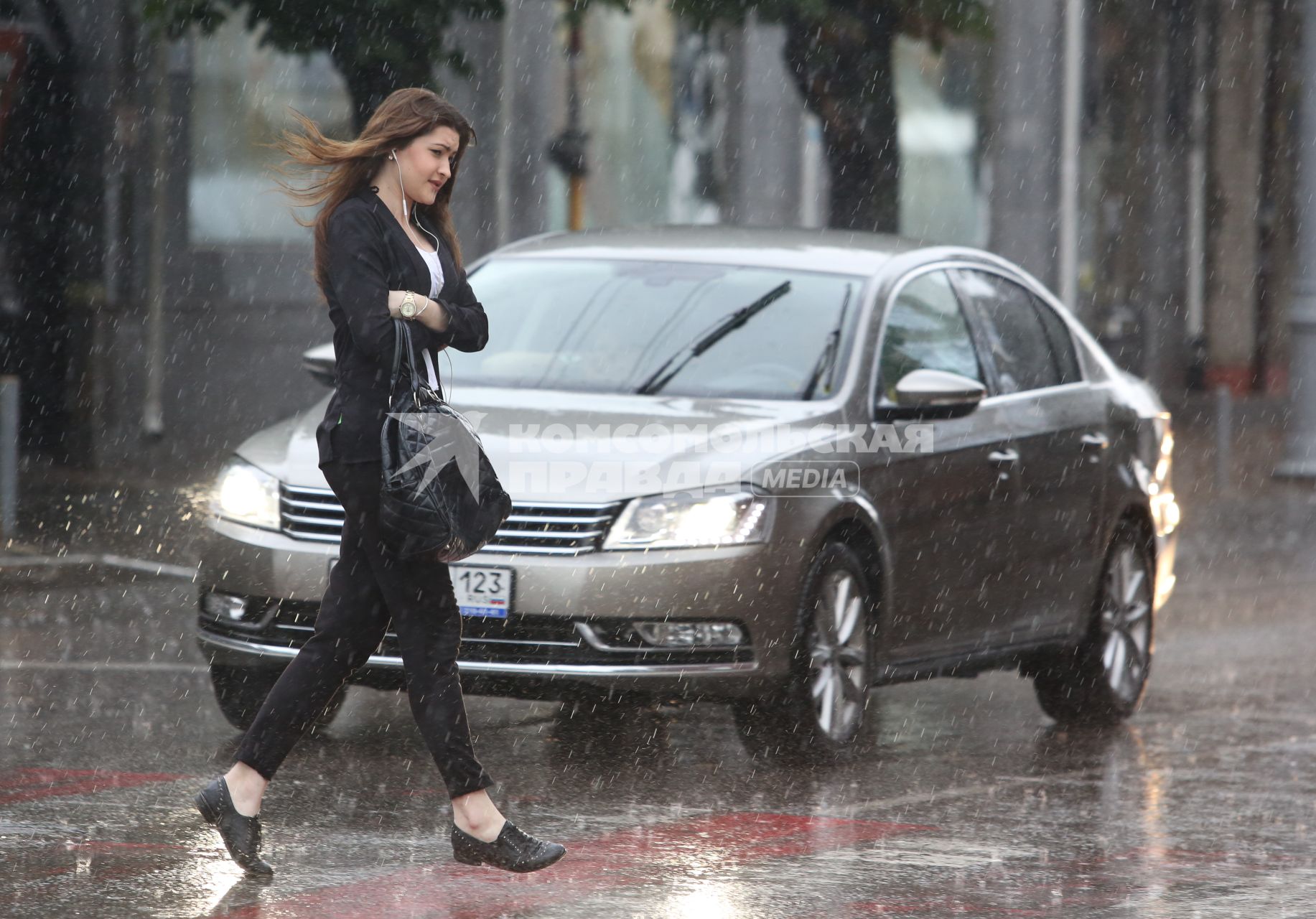 Девушка мокнет под дождем без зонта.