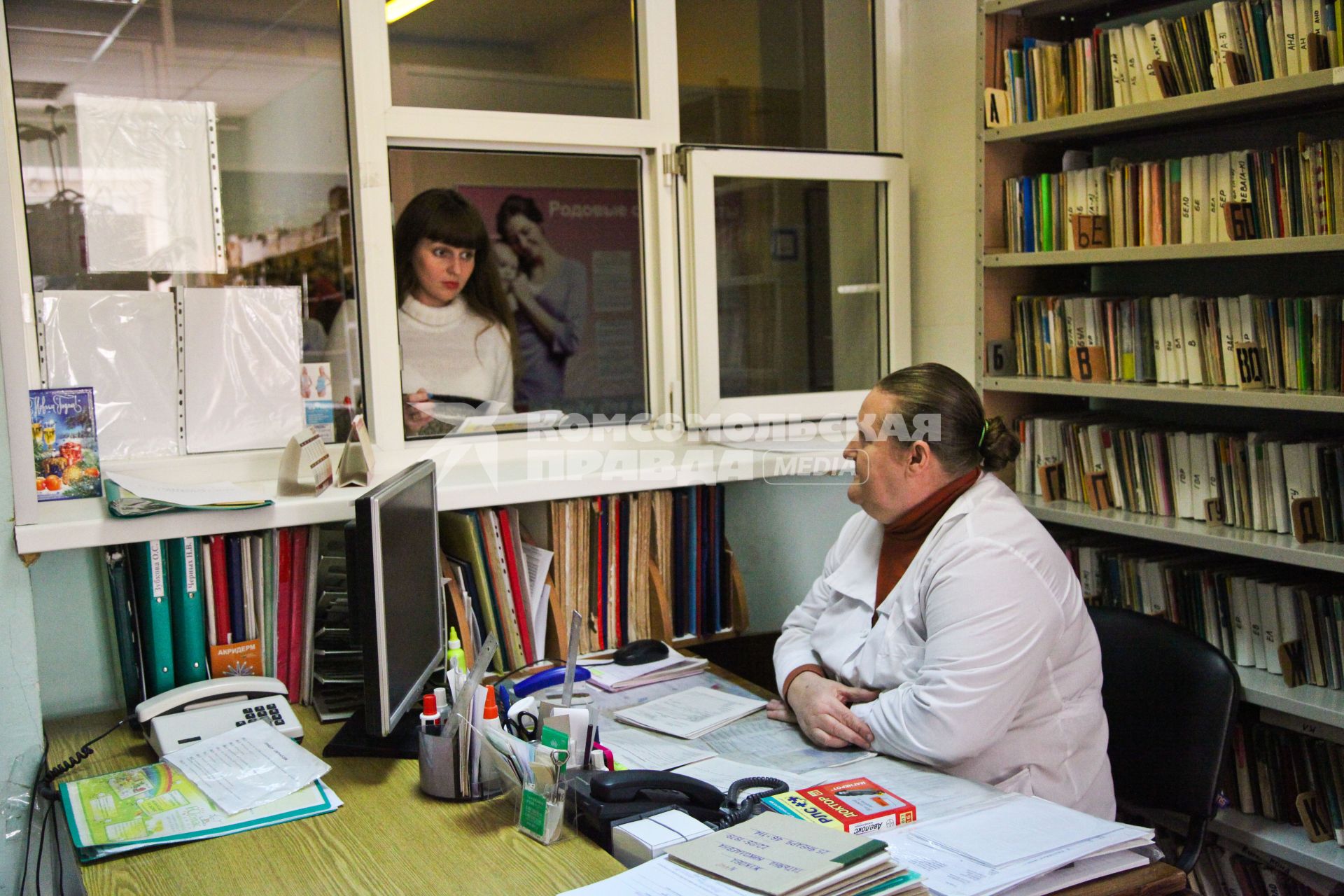 Женщина у окна регистратуры в женской консультации