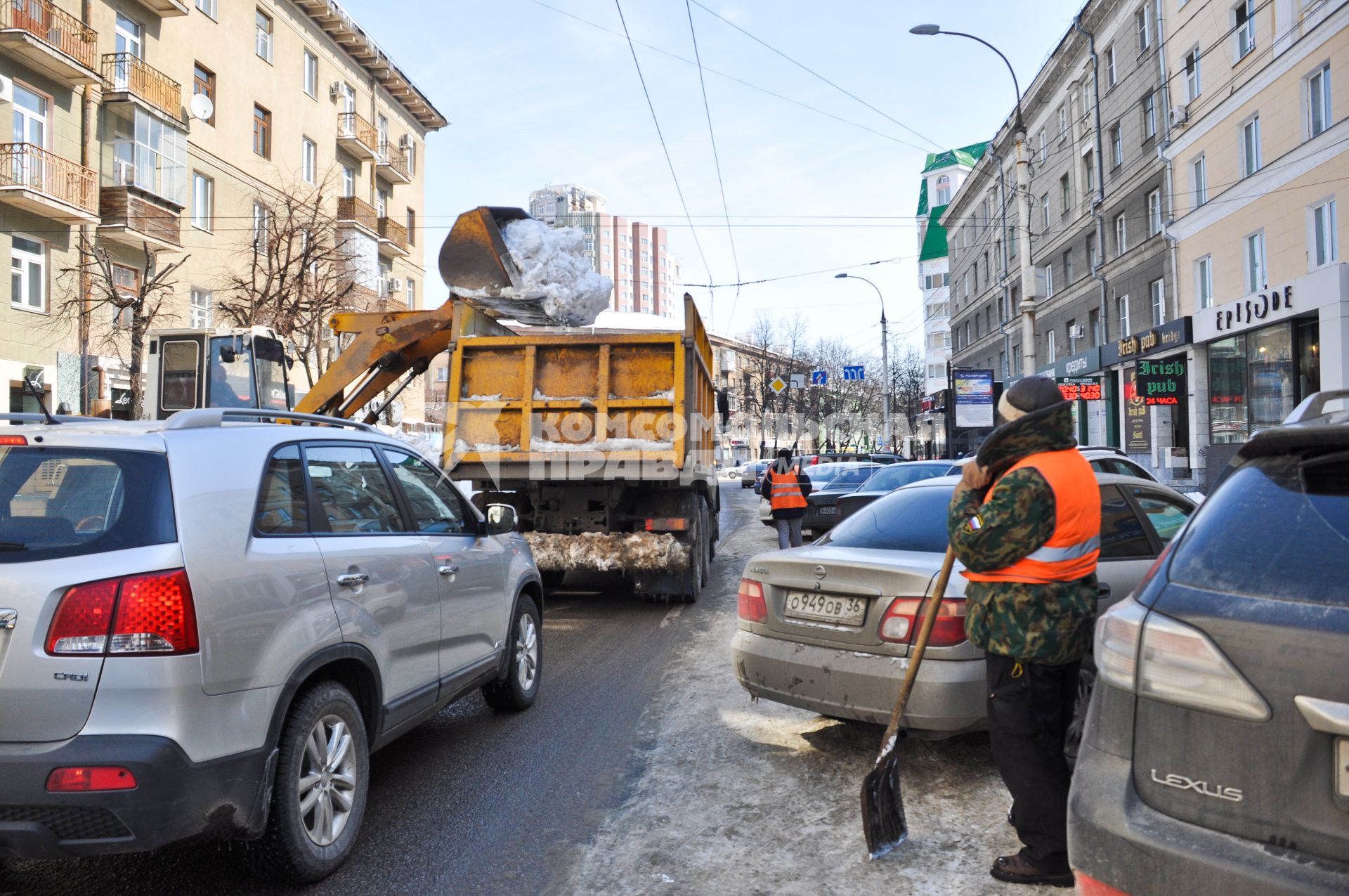 Пока работники коммунальных служб наблюдают за погрузкой снега, за грузовиком скапливается пробка