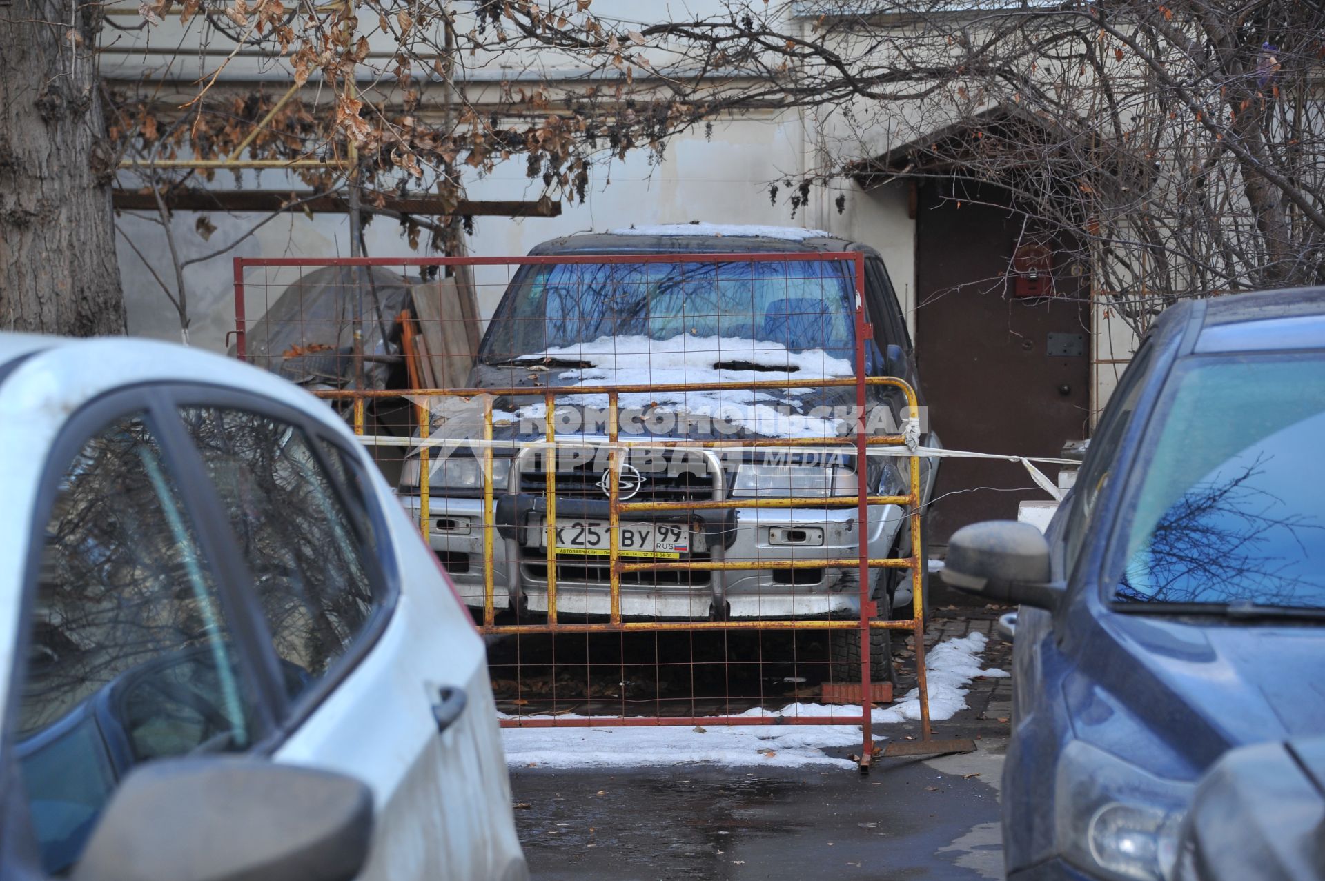 Парковка автомобилей. На снимке: припаркованный автомобиль загороженный забором.