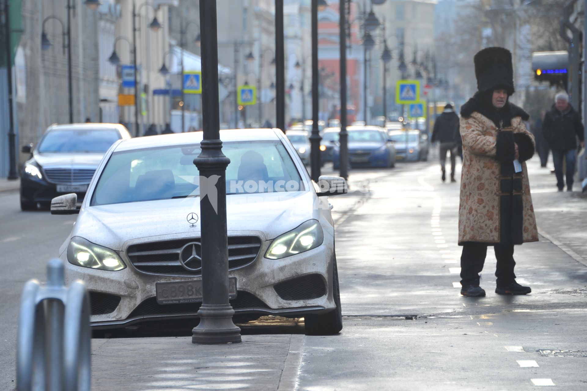 Припаркованный автомобиль около фонарного столба.