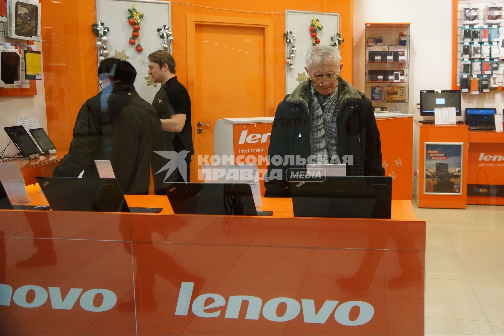 посетители смотрят ноутбуки в фирменном магазине Леново (Lenovo)