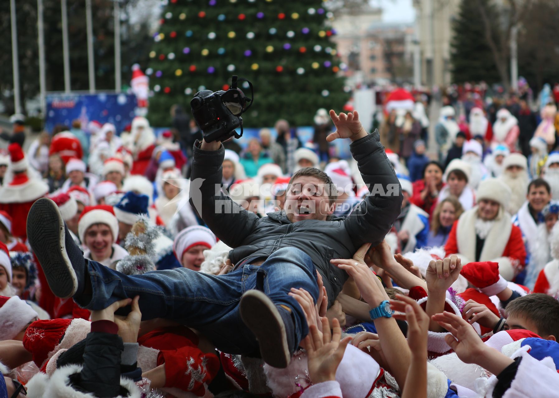 Деды Мороза катают на руках фотографа который прыгнул к ним со сцены во время парада Дедов Морозов в Крансодаре.