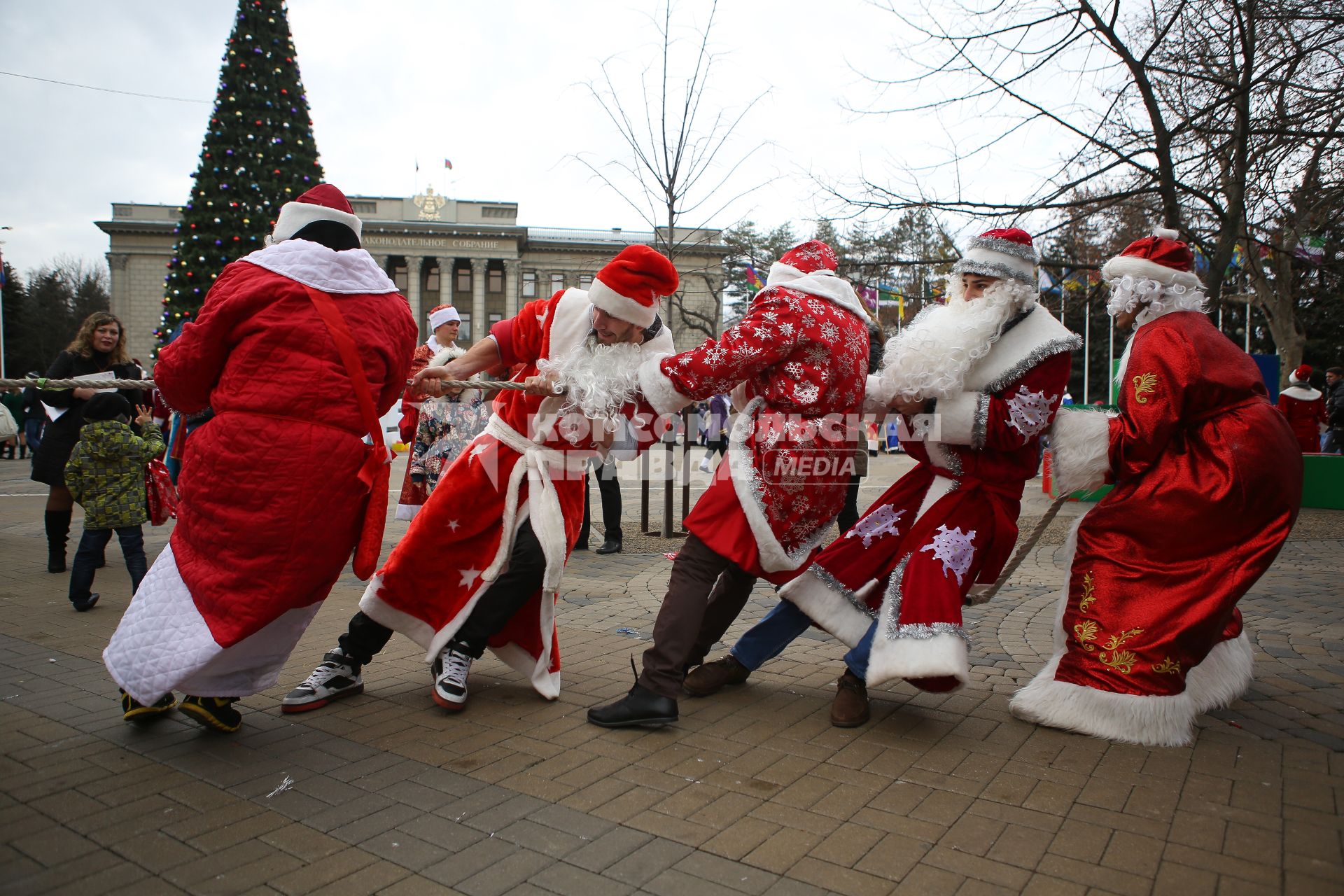 Деды морозы учавствуют в конкурсе по перетягиванию каната во время парада Дедов Морозов в Краснодаре на площади Пушкина
