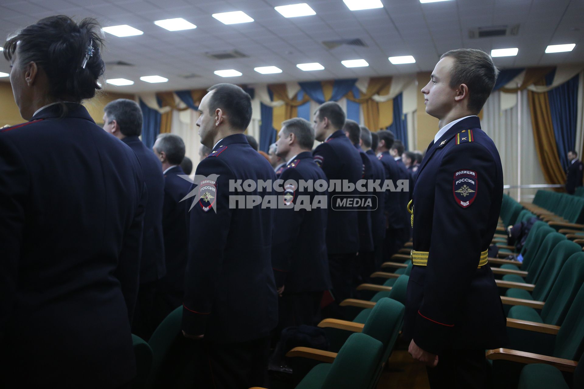 Курсант университета МВД стоит за спинами офицеров в актовом зале главного управления МВД по краснодарскому краю во время торжественной церемонии крепления нового полотнища знамени к древку