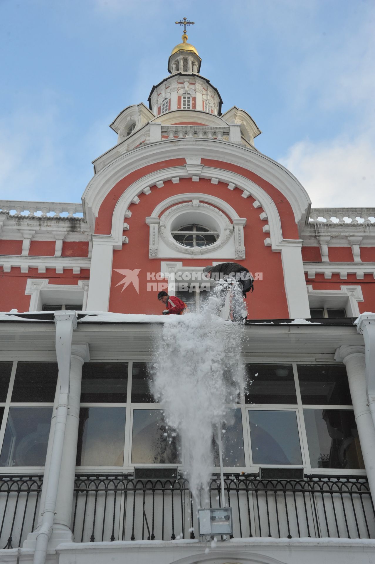 Последствия снегопада в Москве. Улица Никольская. На снимке: рабочий счищает снег с пристройки Заиконоспасского мужского монастыря.