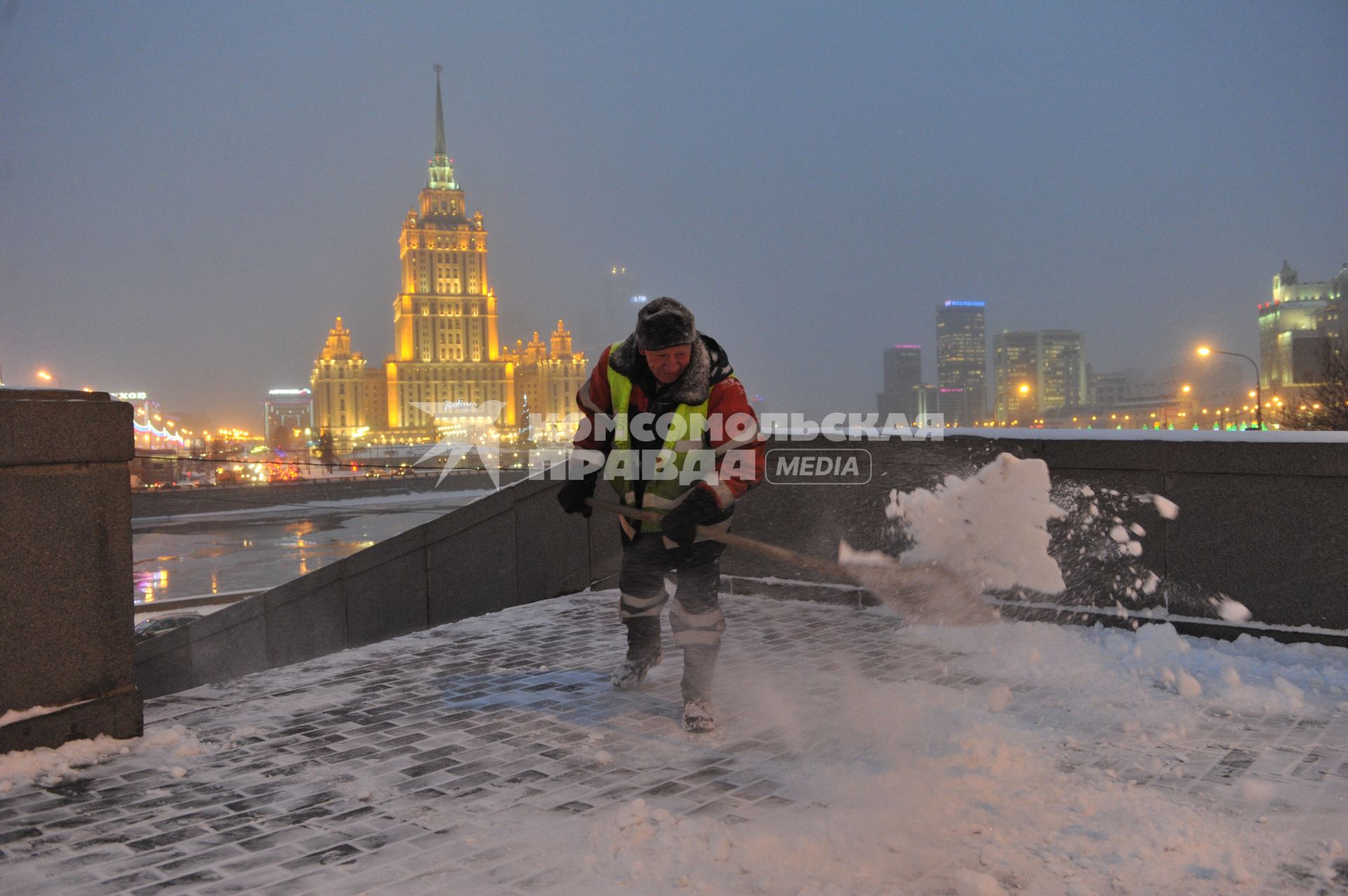 Последствия снегопада в Москве. На снимке: дворник убирает снег на мосту Краснопресненской набережной.