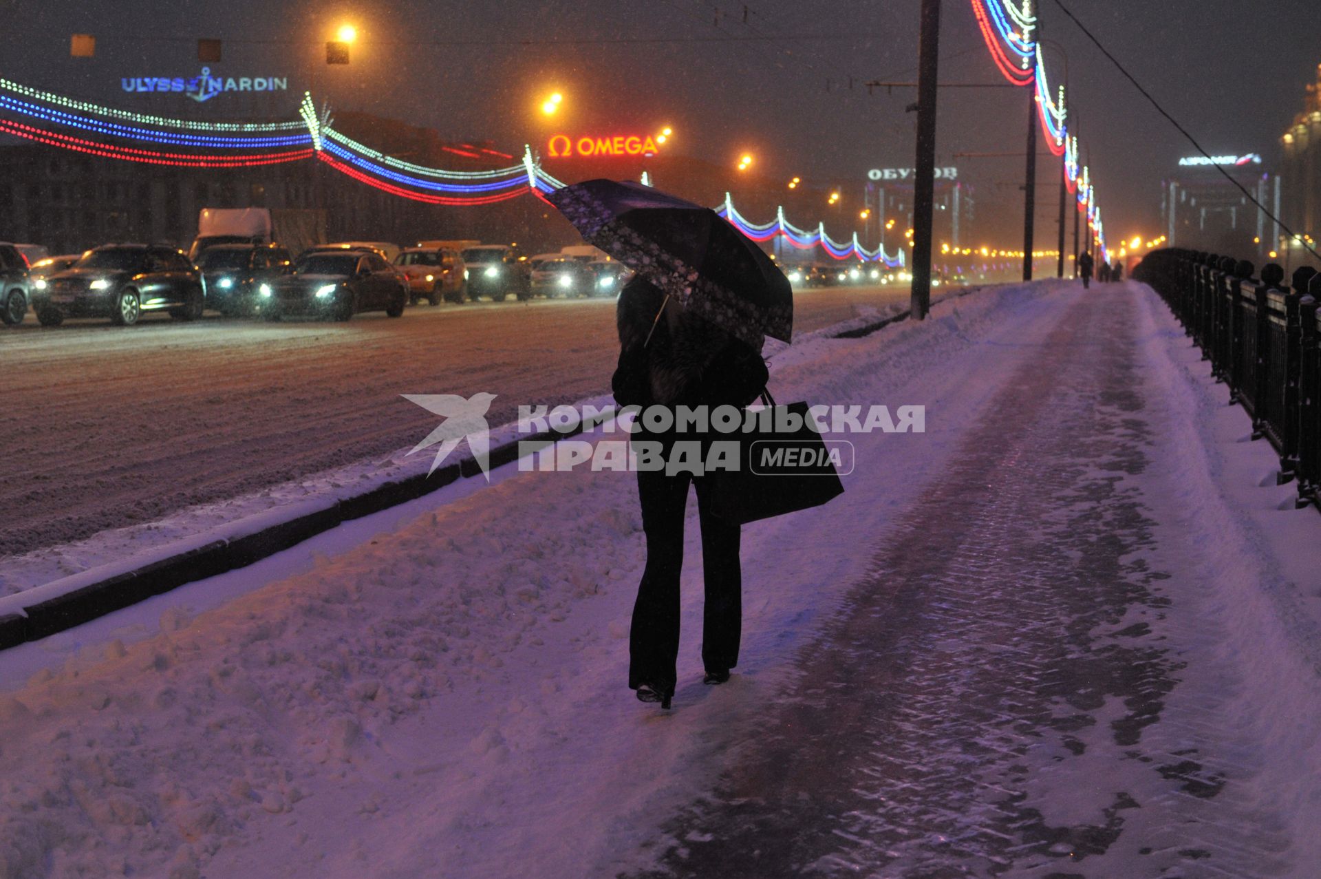 Снегопад в Москве. На снимке: женщина под зонтом идет по мосту.