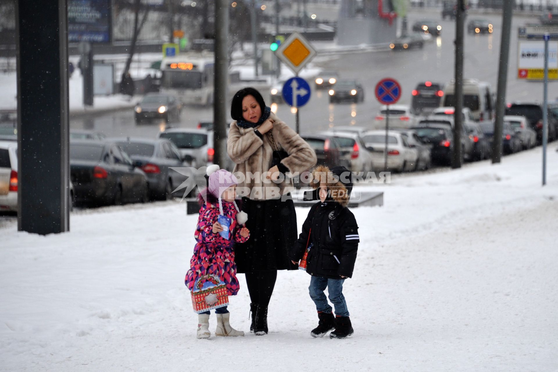 Снегопад в Москве. На снимке: женщина с детьми идут по улице.