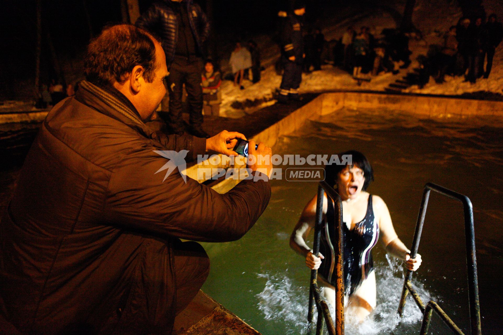 Крещенские купания в Ставрополе. На снимке: мужчина фотографирует женщину в купели.