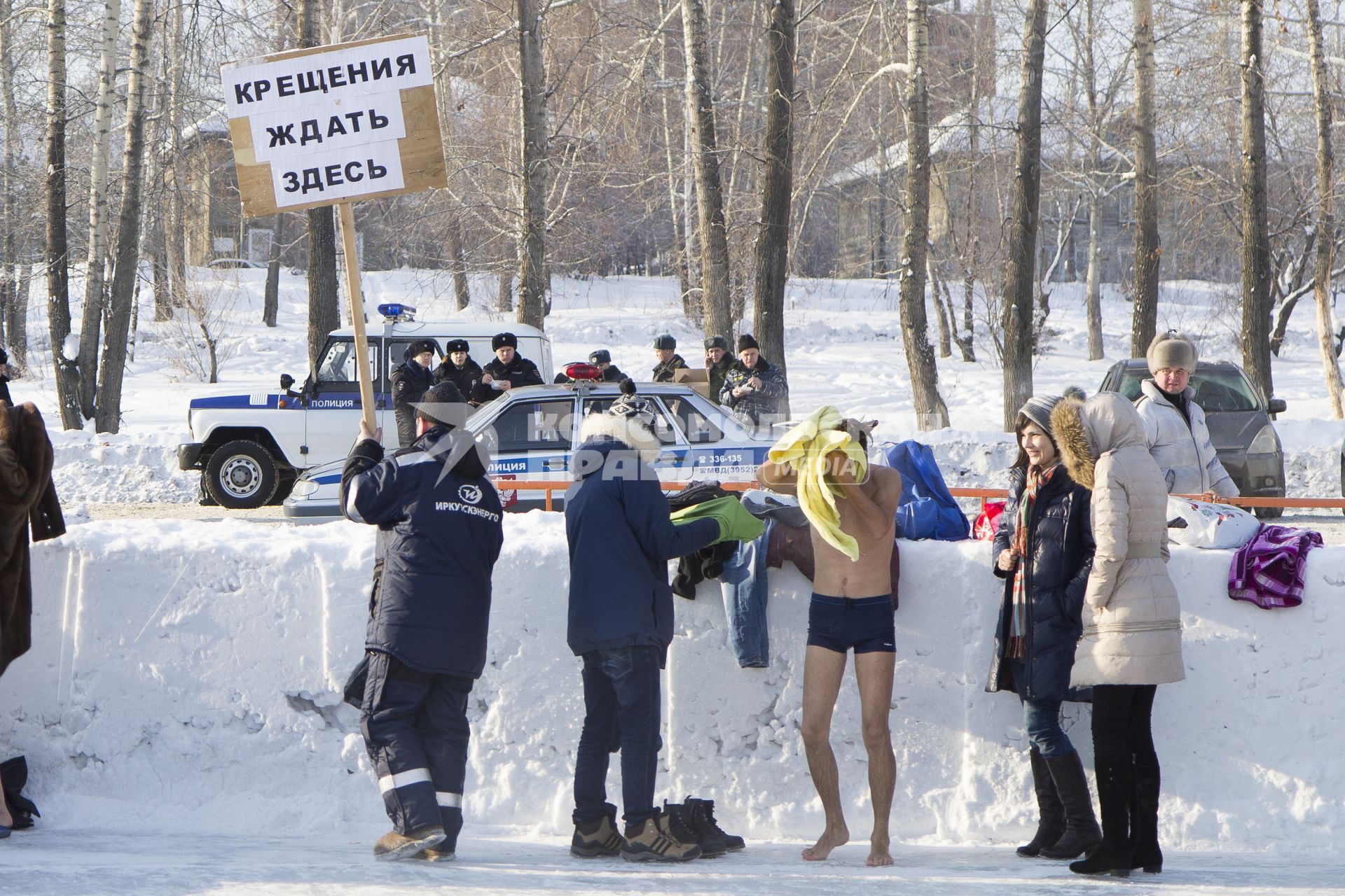 Крещенские купания в Иркутске. На снимке: мужчина держит табличку `Крещения ждать здесь`.