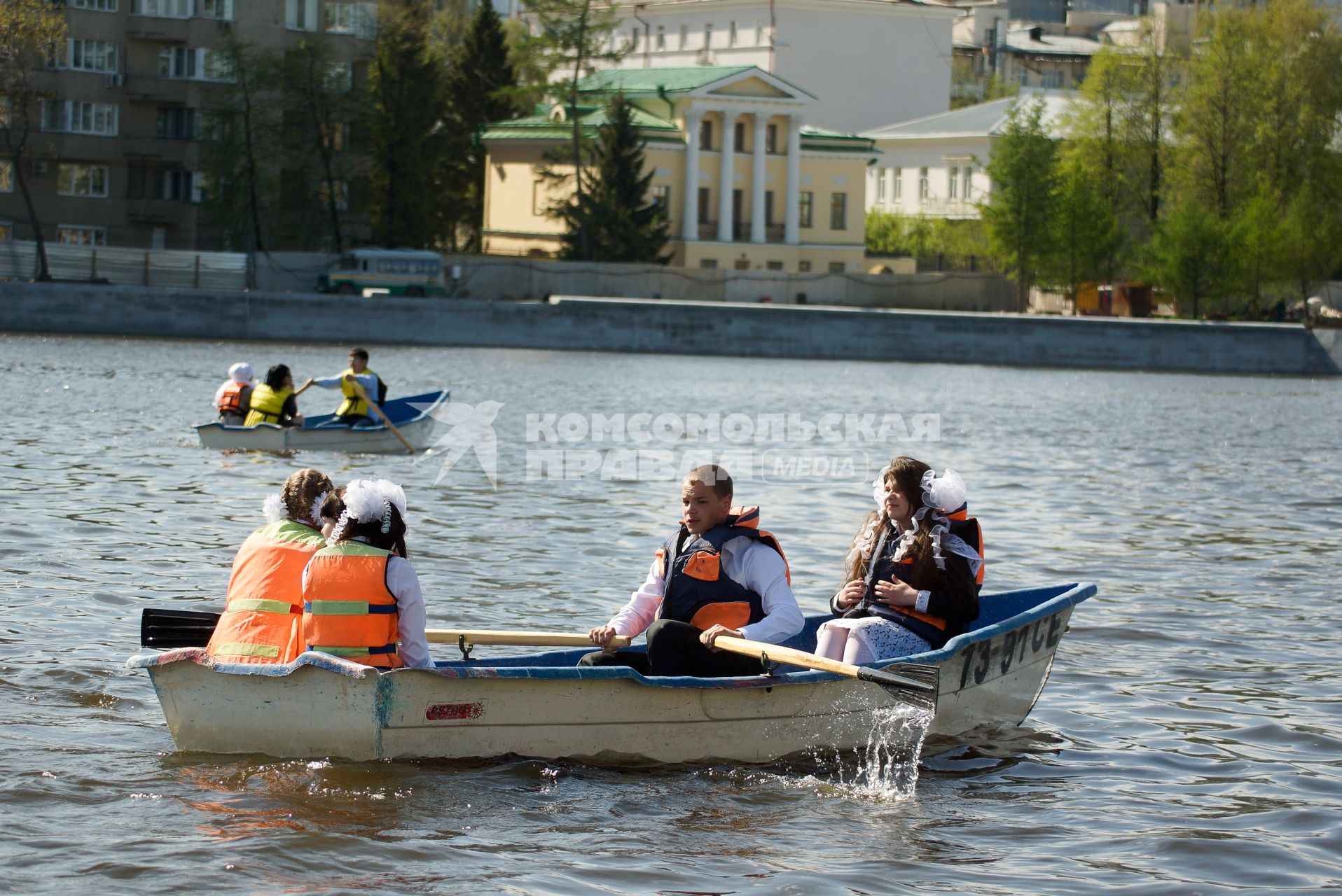 выпускники в спасательном жилете, катаются на лодке по Исети, во время празднования последнего звонка в Екатеринбурге.