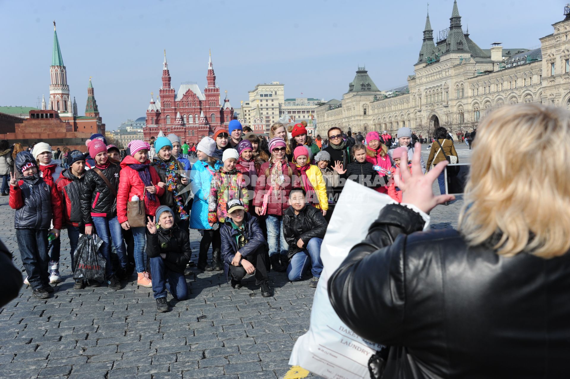 Женщина фотографирует детей на Красной площади.