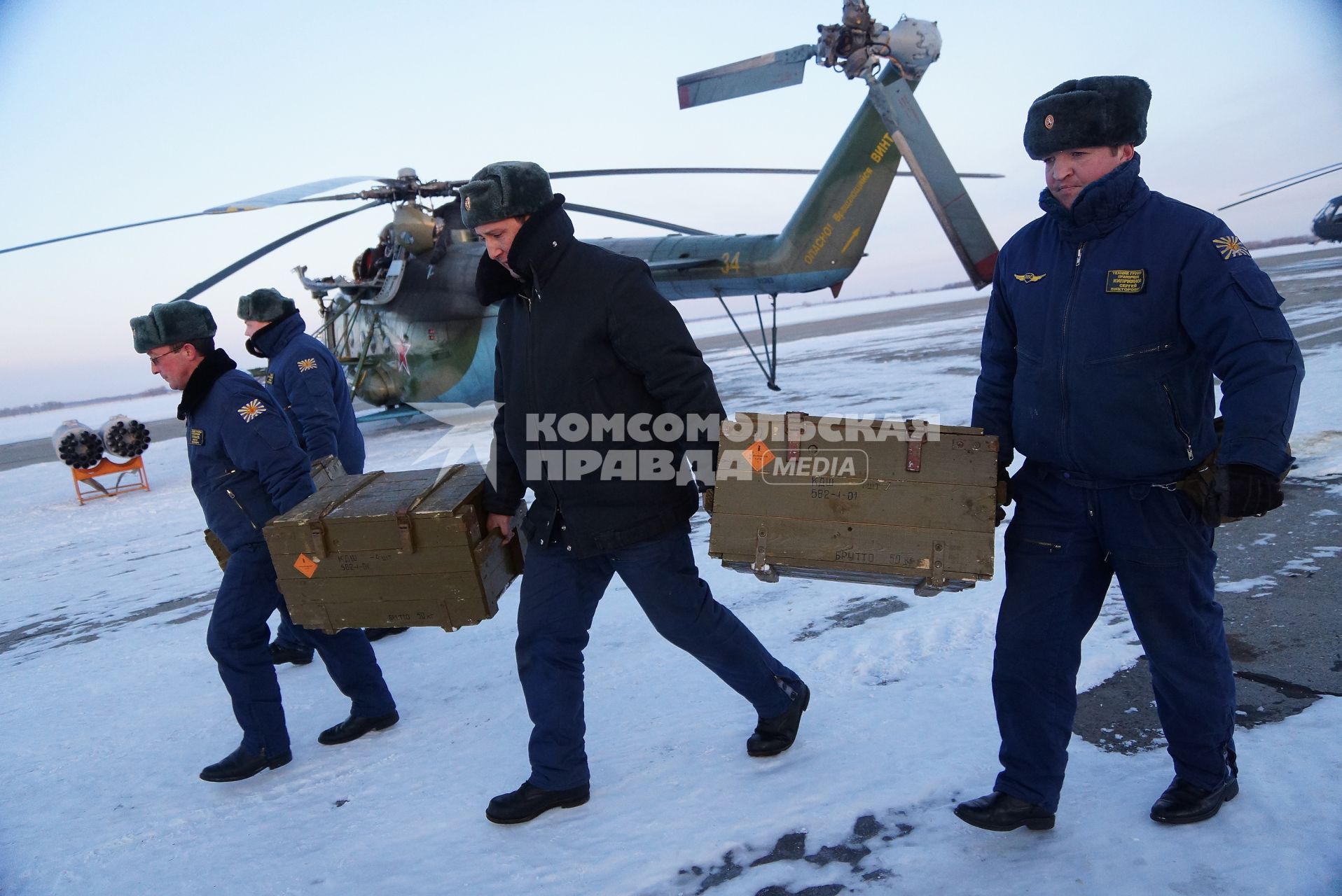 техники несут ящики с боеприпасами для вертолетов Ми-8 войсковой части ВВС в Каменске-Уральском, после полетов на учебное  воздушное минирования