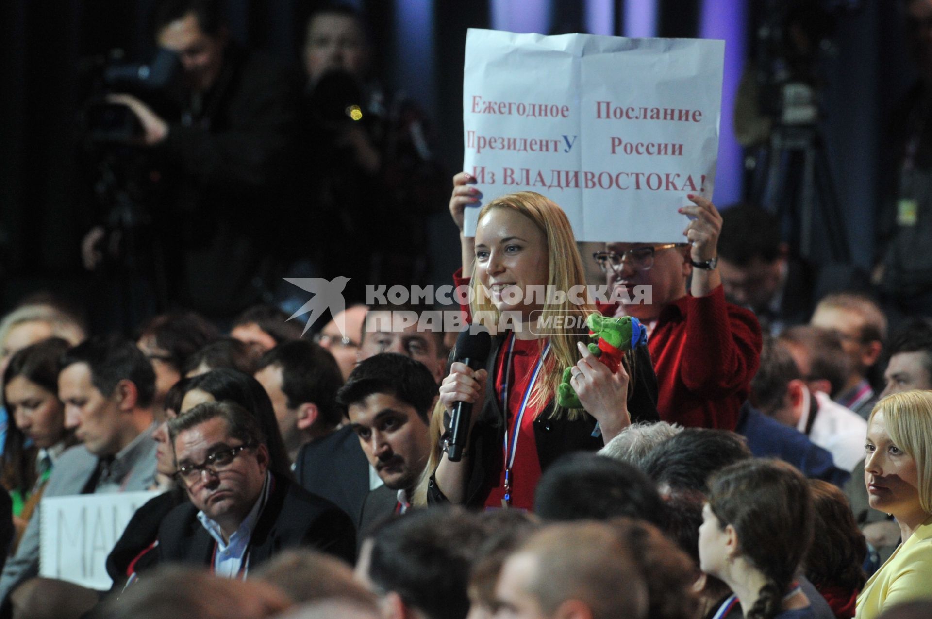 Большая пресс-конференция президента РФ В. Путина в Центре международной торговли. На снимке: корреспондент `Авторадио` Наталья Сельдемирова (на первом плане) и главный редактор дальневосточной газеты `Народное вече` Мария Соловьенко с плакатом `Ежегодное Послание ПрезидентУ России из Владивостока!`.