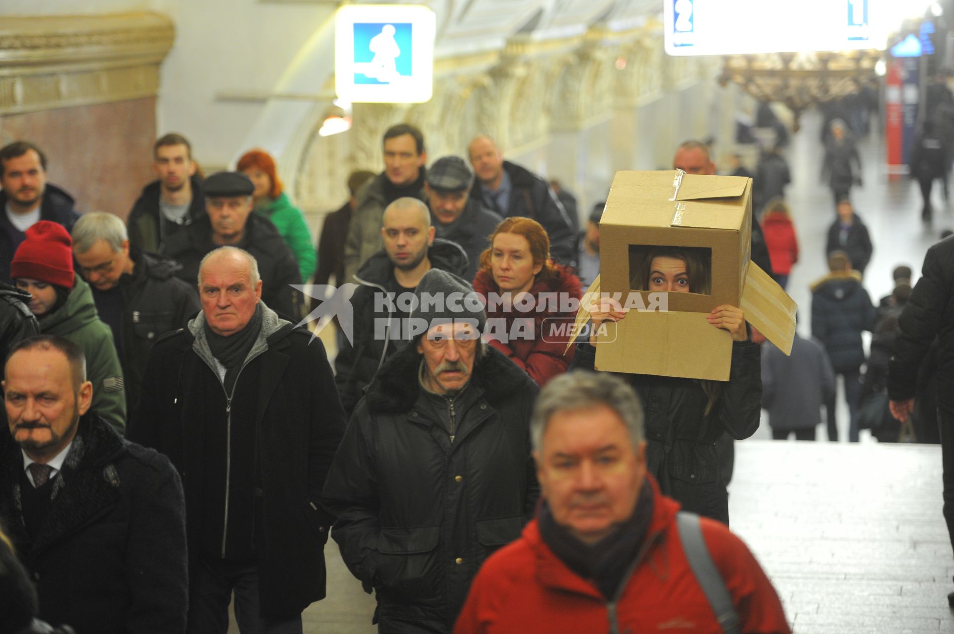 Девушка с коробкой на голове в московском метро.