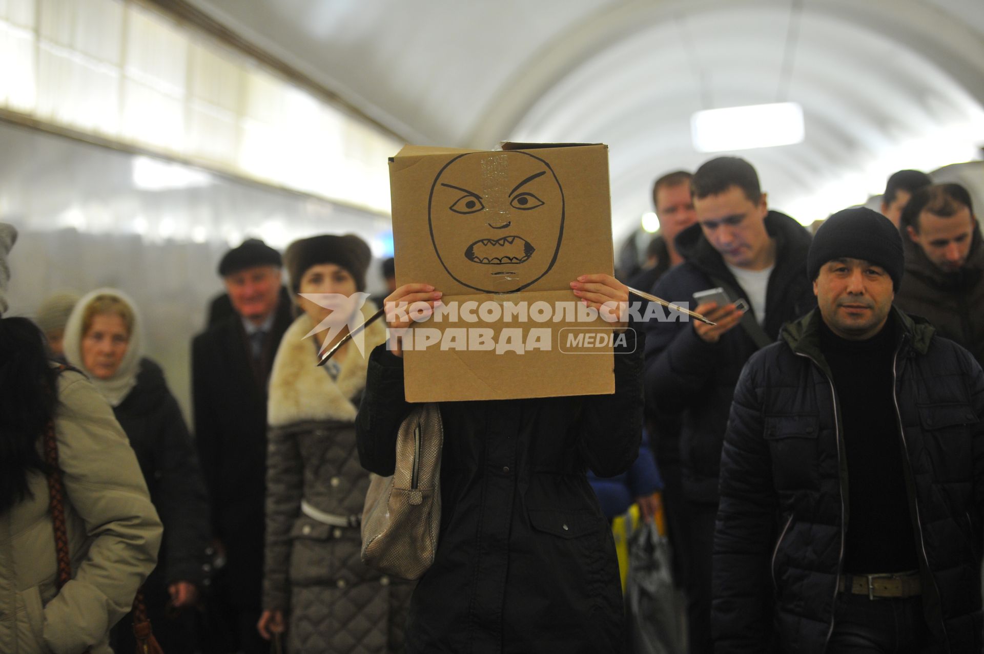 Девушка с коробкой на голове в московском метро.