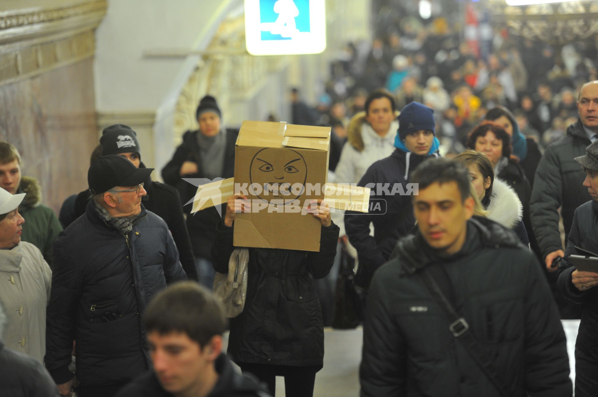 Девушка с коробкой на голове в московском метро.