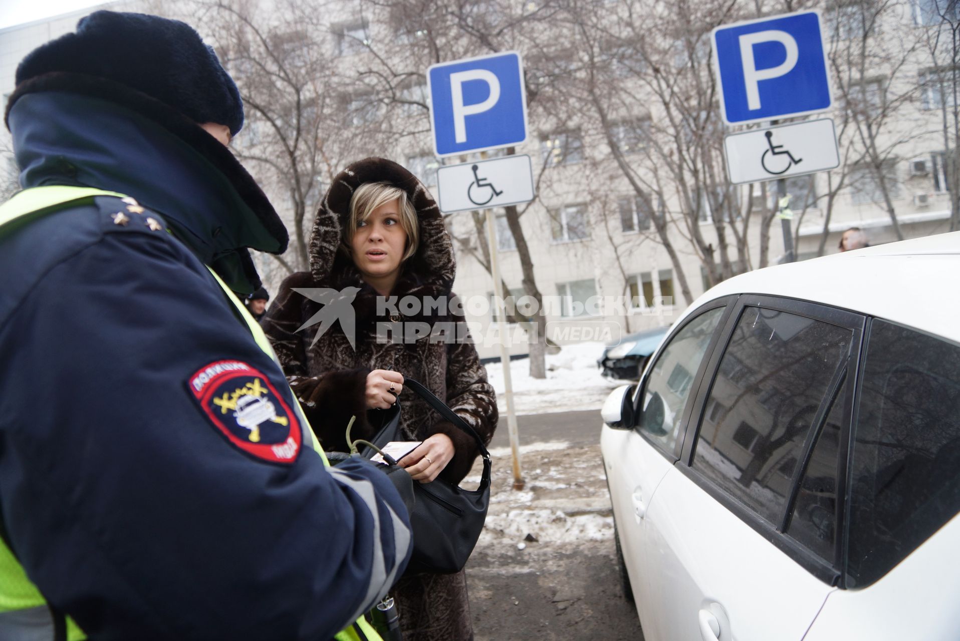 Сотрудник ДПС ГИБДД разговаривает с женщиной припарковавшей своя автомобиль на стоянке для инвалидов. Совместный рейд ГИБДД с инвалидами-автомобилистами \"За доступную парковку для людей с инвалидностью\". Министерства социальной политики г.Екатеринбург