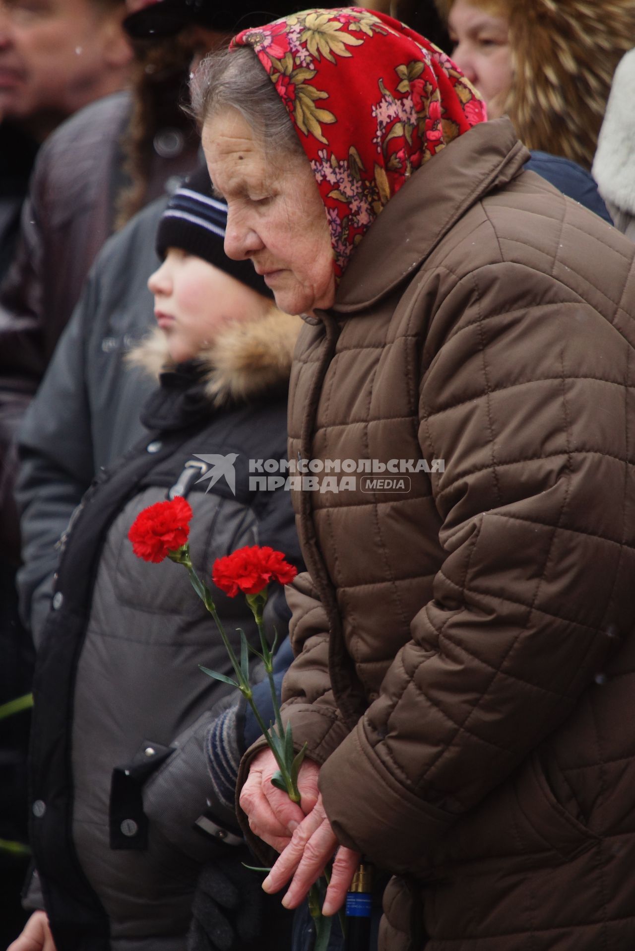 пожилая женщина держит букет гвоздик, во время вахты памяти войнов погибших в афганистане, у памятника войнам-интернационалистам \"Черный тюльпан\" в Екатеринбурге