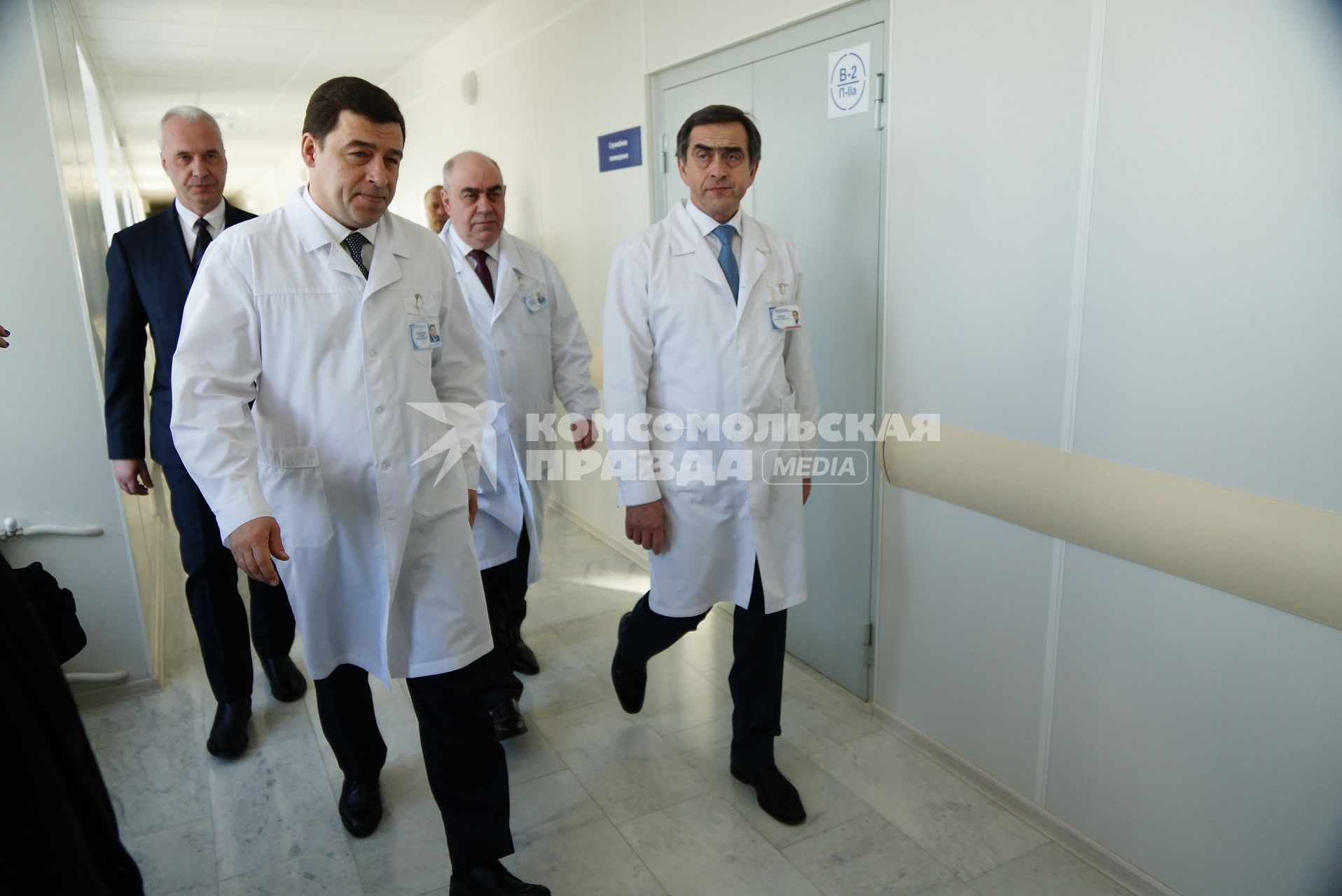 губернатор Свердловской области Евгений Куйвашев (слева) и главный врач ОКБ№1 Феликс Бадаев (в центре справа) идут по коридору отделения трансплантологии костного мозга областной клинической болницы №1 в Екатеринбурге