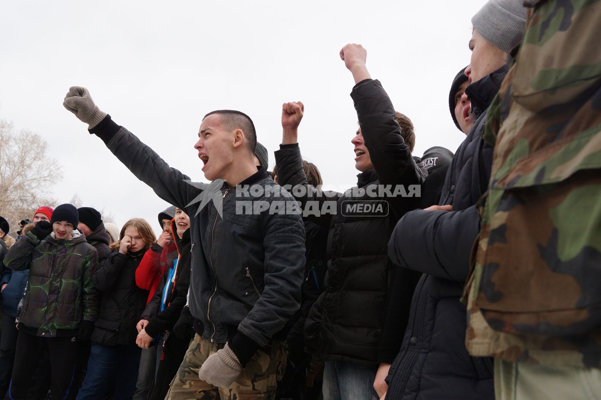 Молодые парни участвуют в народной забаве \"Стенка на стенку\". Празднование Масленицы в Харитоновском парке, в Екатеринбурге