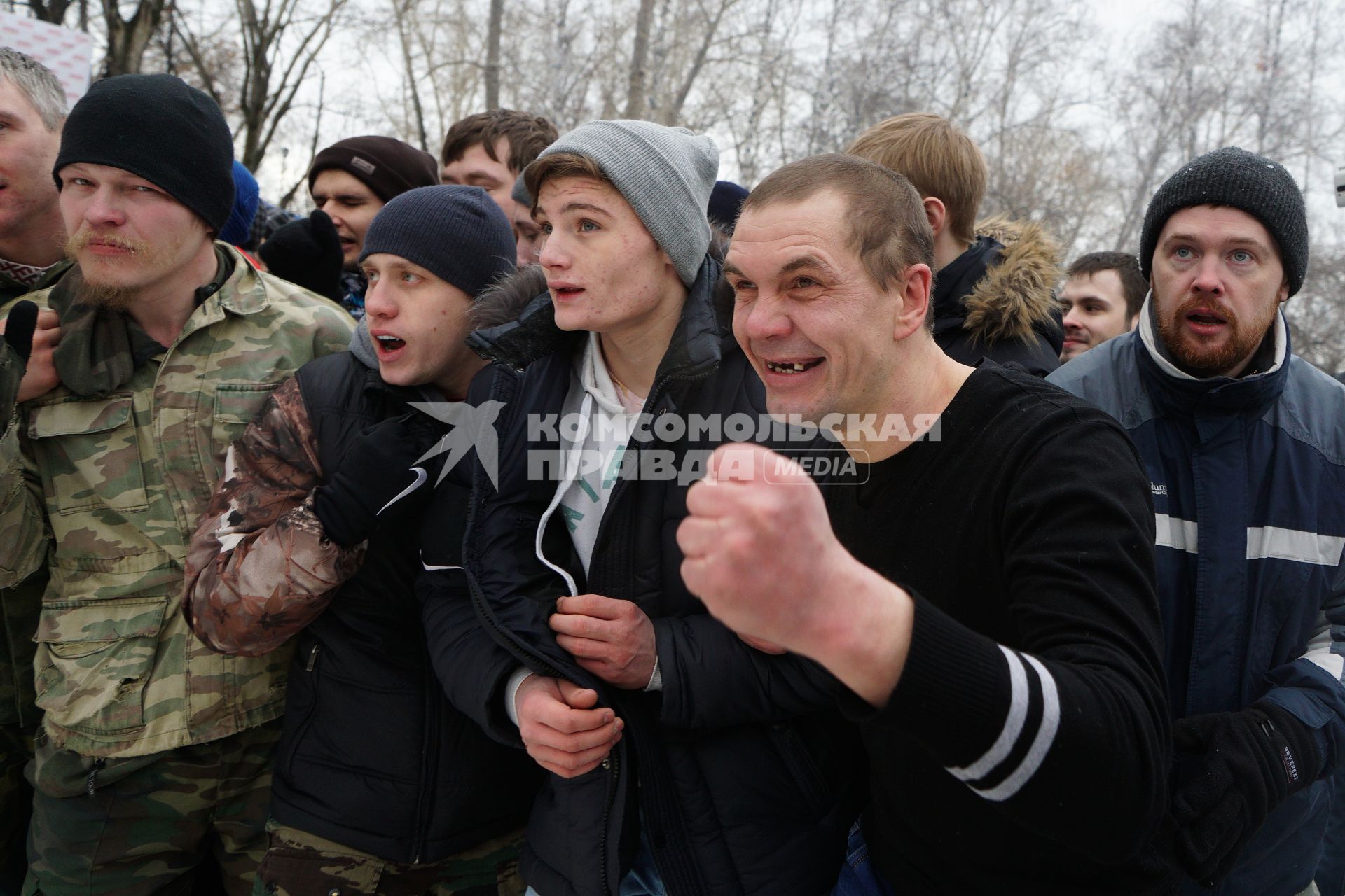 Молодые парни и мужчины участвуют в народной забаве \"Стенка на стенку\". Празднование Масленицы в Харитоновском парке, в Екатеринбурге