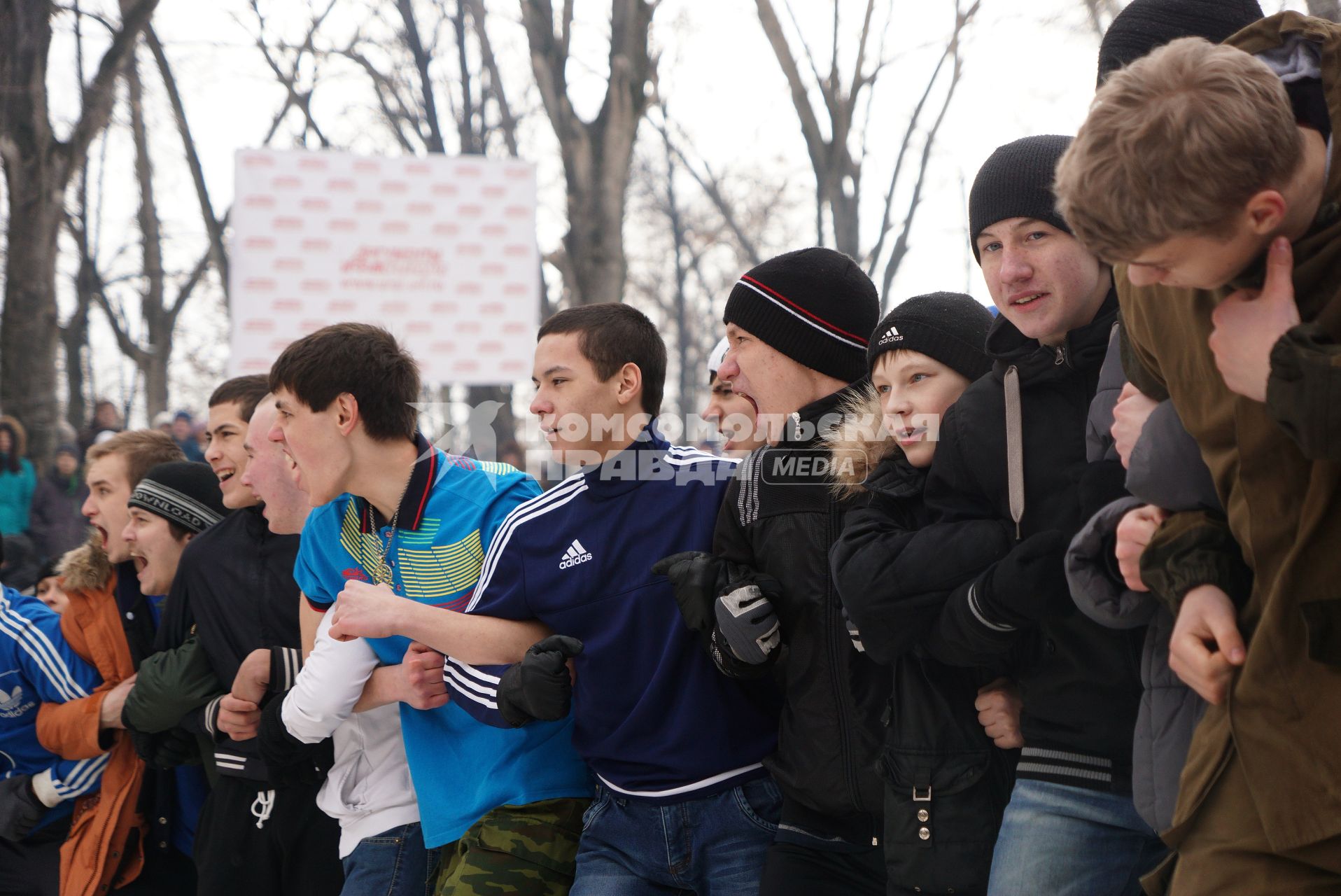 Молодые парни участвуют в народной забаве \"Стенка на стенку\". Празднование Масленицы в Харитоновском парке, в Екатеринбурге