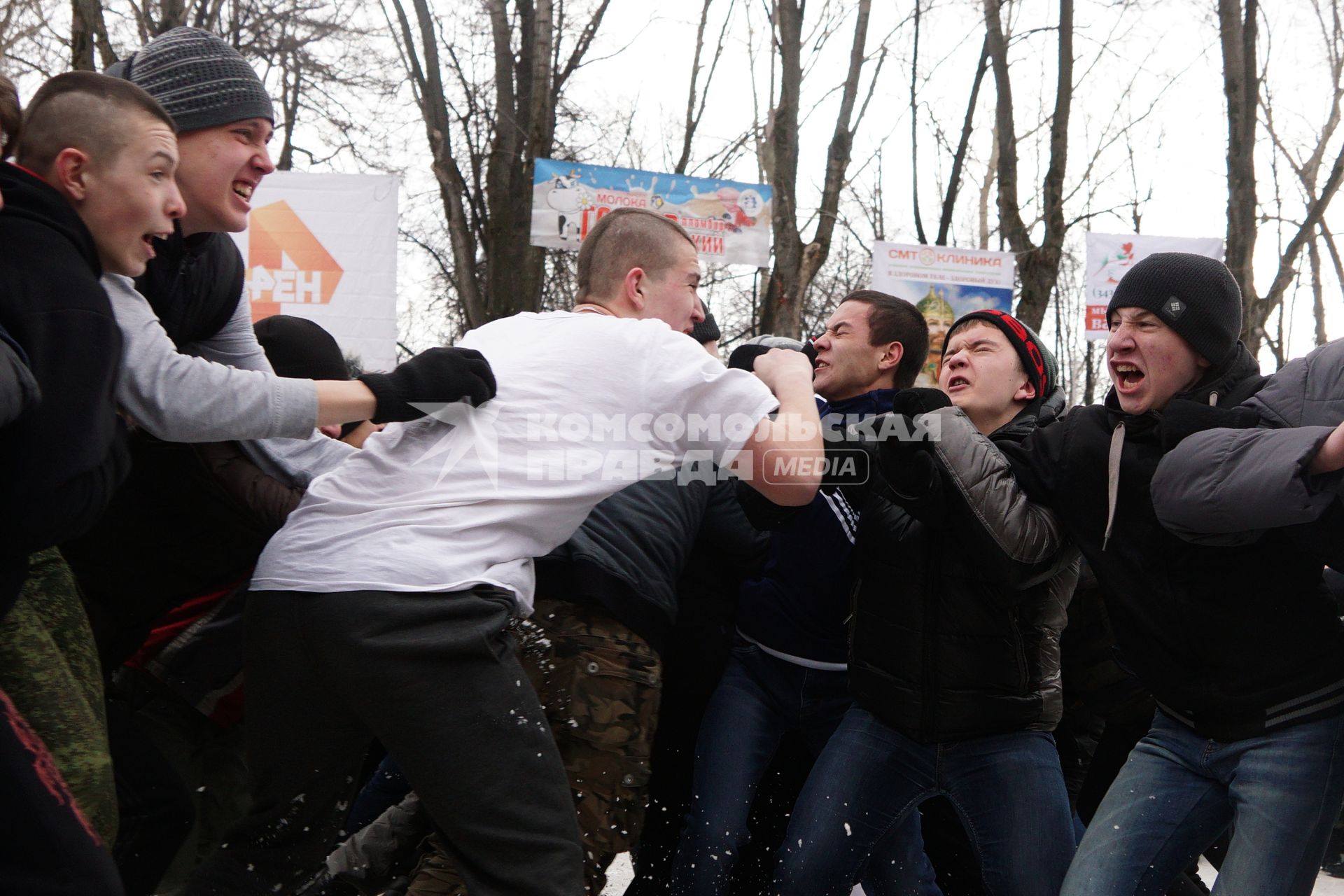 Молодые парни участвуют в народной забаве \"Стенка на стенку\". Празднование Масленицы в Харитоновском парке, в Екатеринбурге