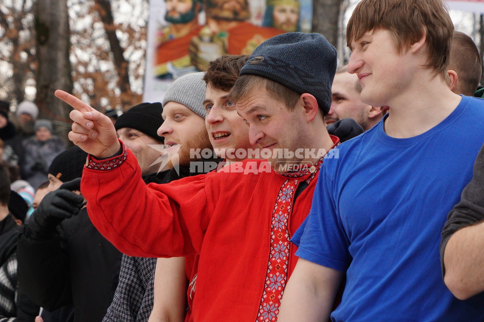 Молодые парни и мужчины участвуют в народной забаве \"Стенка на стенку\". Празднование Масленицы в Харитоновском парке, в Екатеринбурге