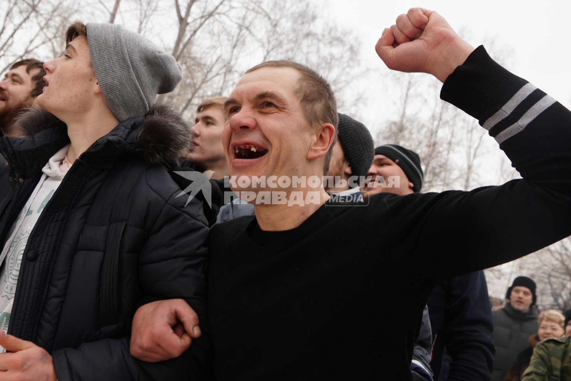 Молодые парни и мужчины участвуют в народной забаве \"Стенка на стенку\". Празднование Масленицы в Харитоновском парке, в Екатеринбурге