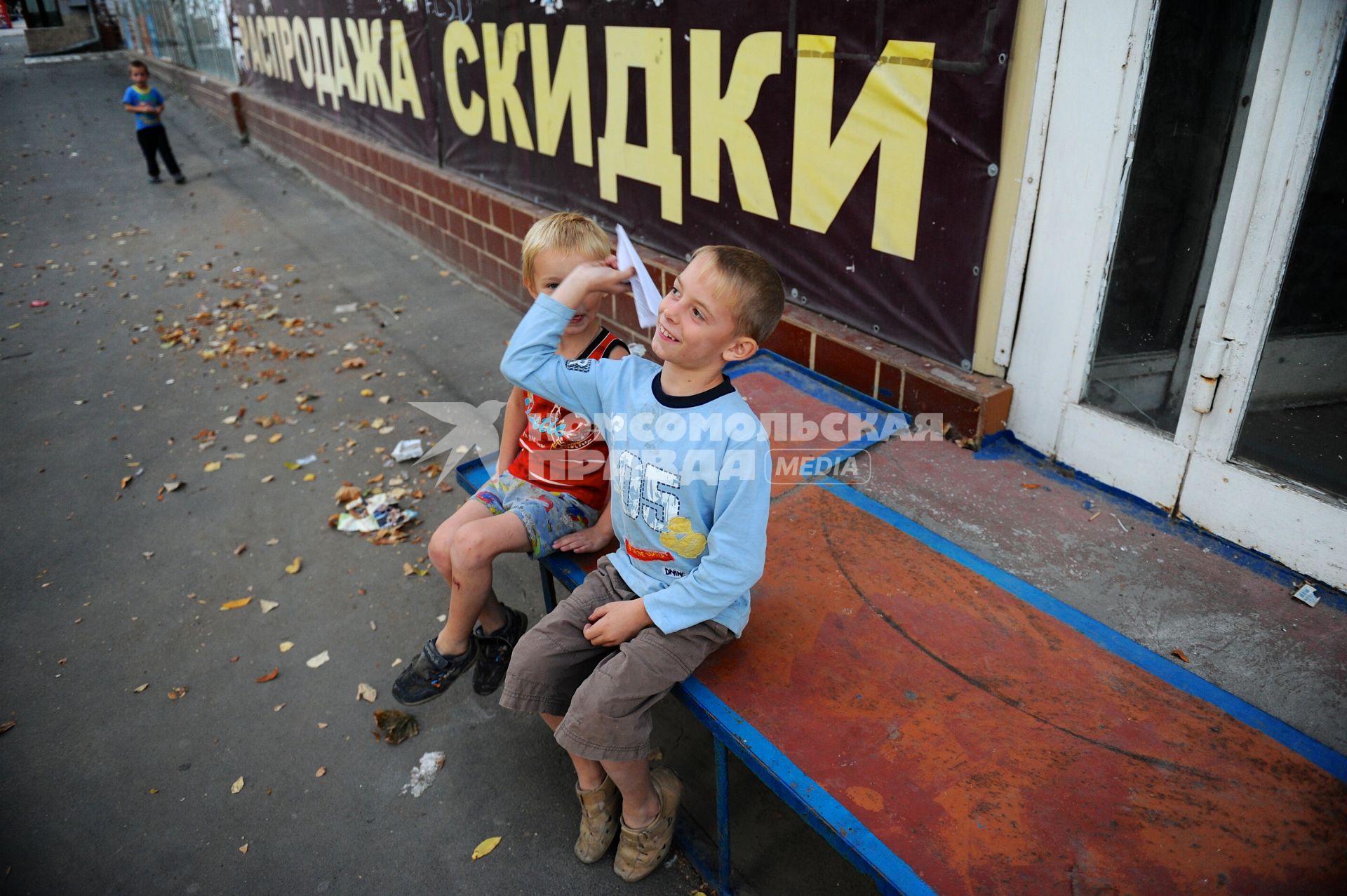 Украина. Донецк. Мальчики играют с бумажным самолетиком.