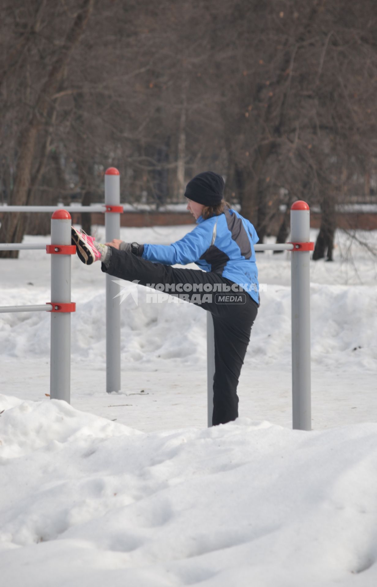 Москва. Девушка делает зарядку на снегу.