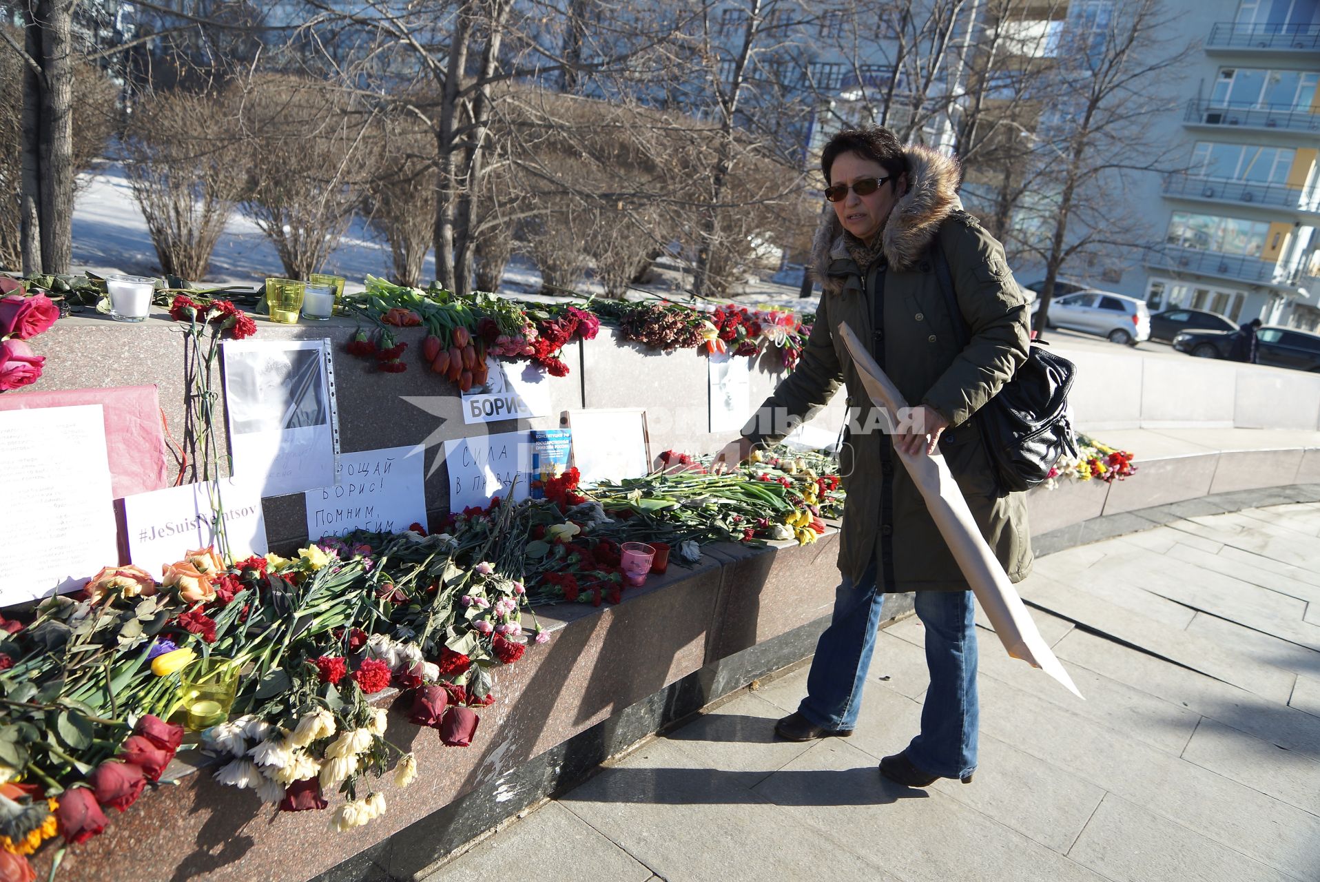 Женщина возлагает цветы у фотографий Бориса Немцова убитого накануне. Памятник Татищеву и Де Генину. Екатеринбург