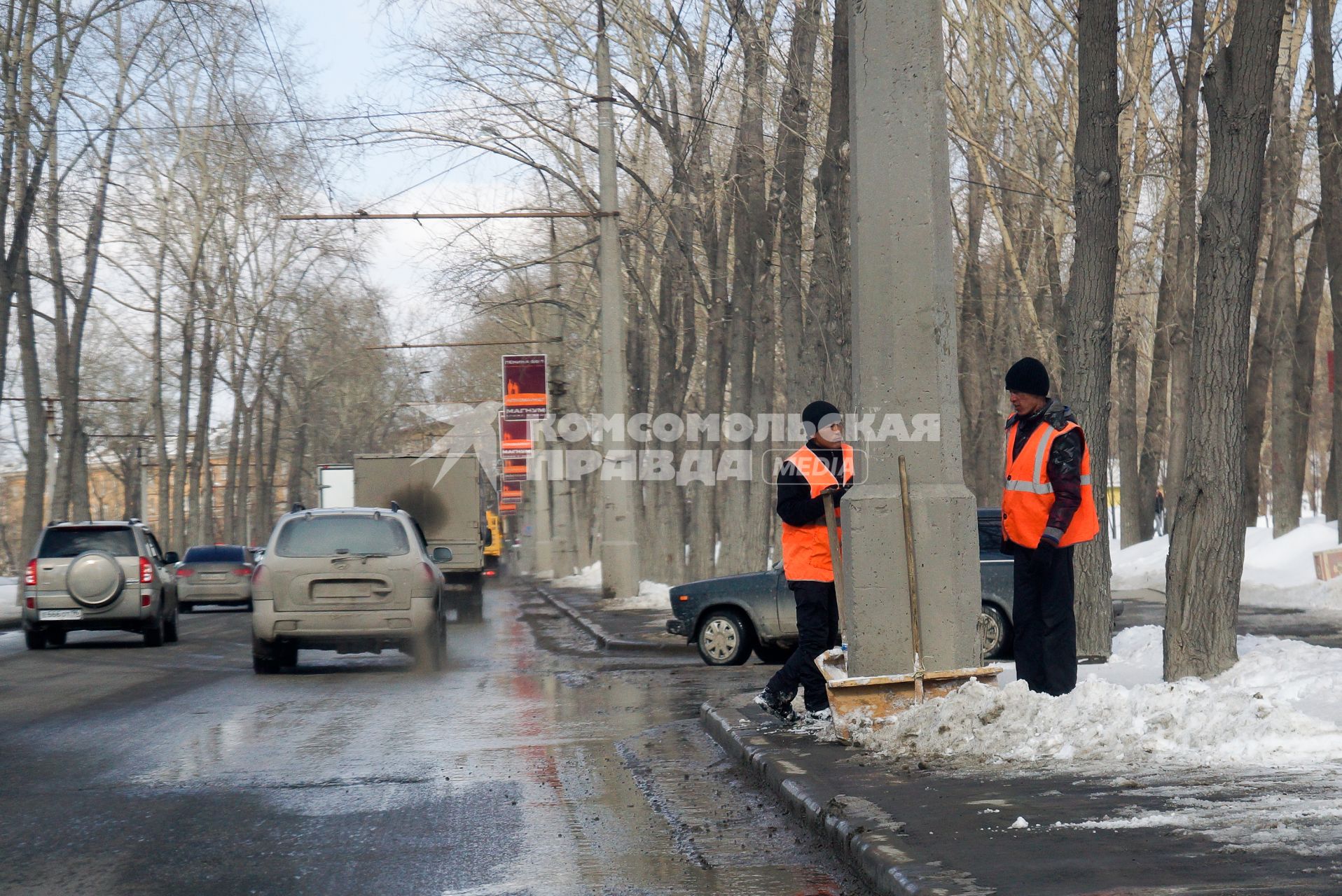 Дворники в оранжевых жилетках, отдыхают во время уборки снега вдоль дороги. Екатеринбург