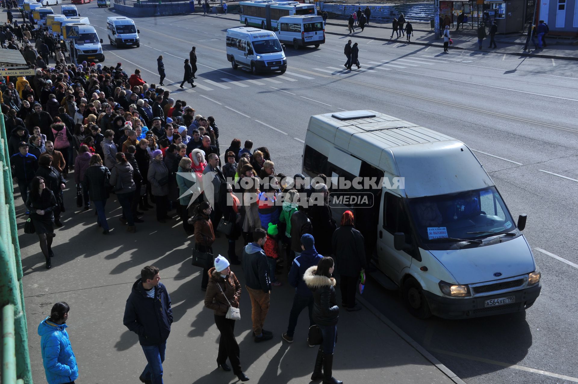 Люди стоят в очереди на маршрутку у станции метро `Выхино` в Москве.