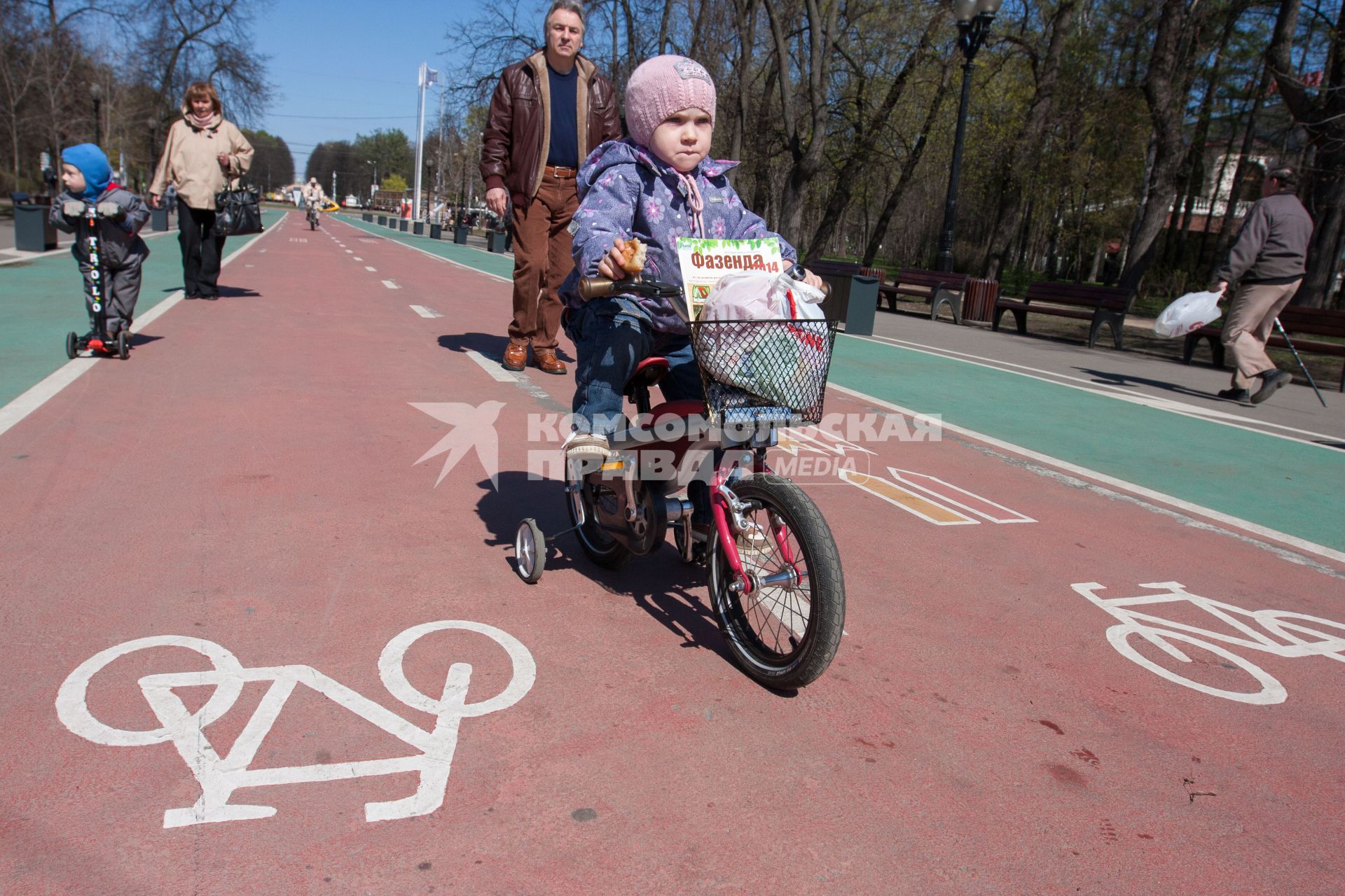 Москва. Ребенок едет на велосипеде по выделенной полосе в парке Сокольники.