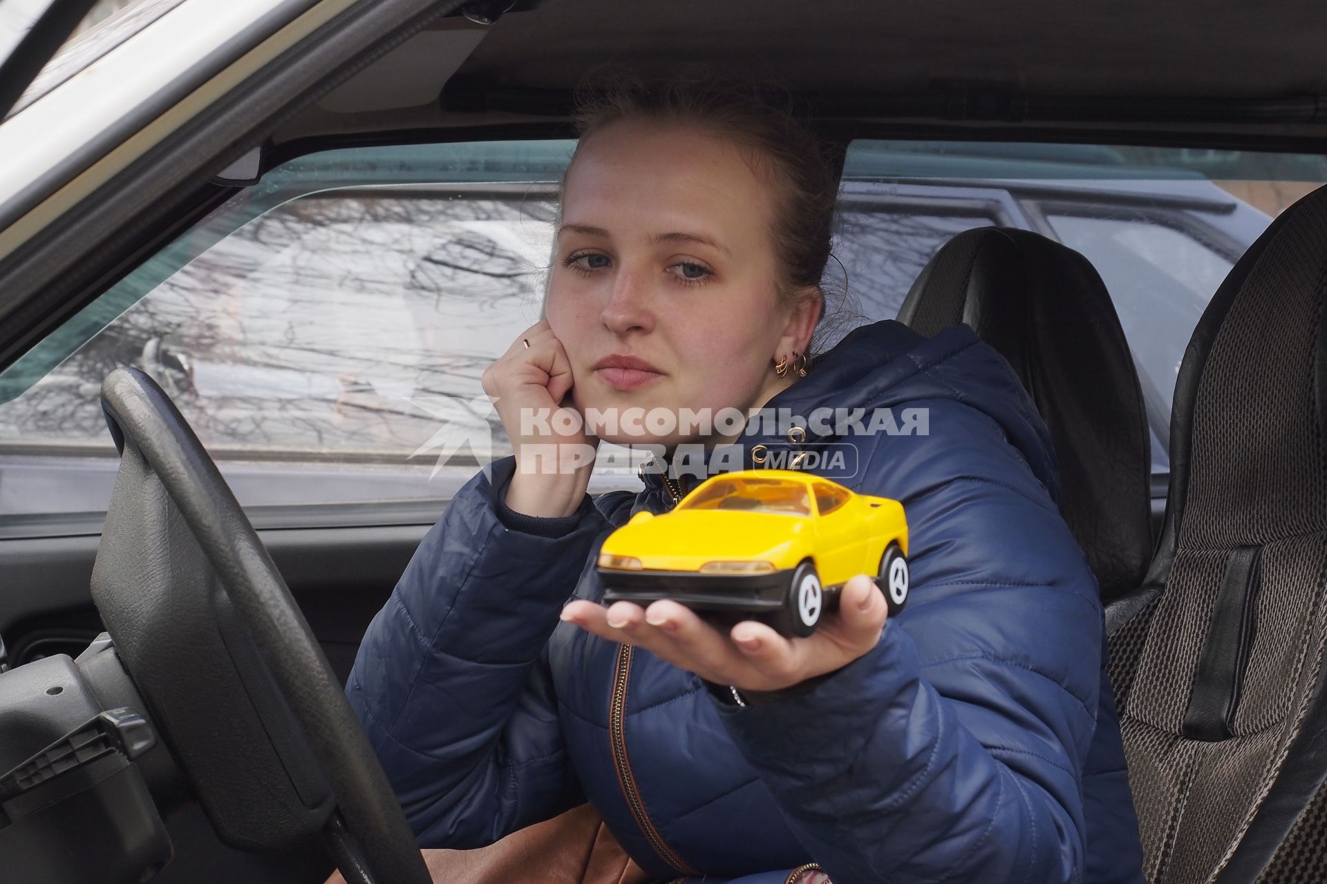 Тула. Девушка в автомобиле с игрушечной машинкой на ладони.