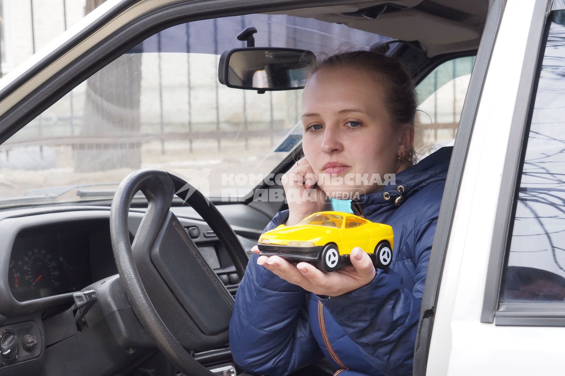 Тула. Девушка в автомобиле с игрушечной машинкой на ладони.