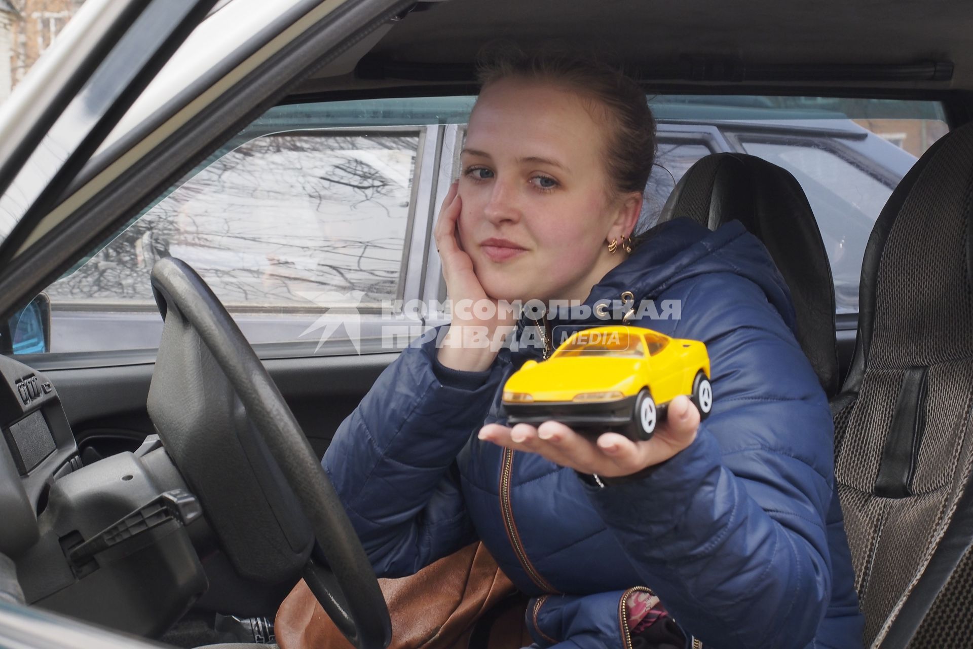 Тула. Девушка в автомобиле с игрушечной машинкой на ладони.