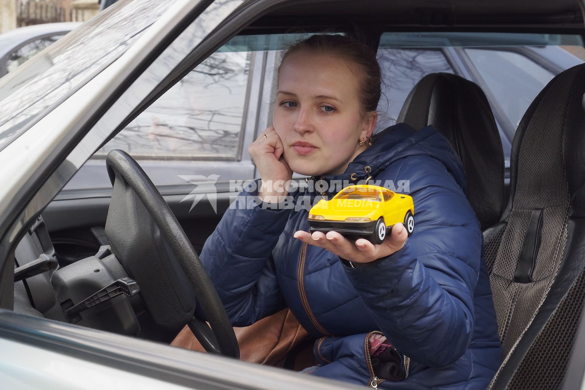 Тула. Девушка в автомобиле с игрушечной машинкой на ладони.