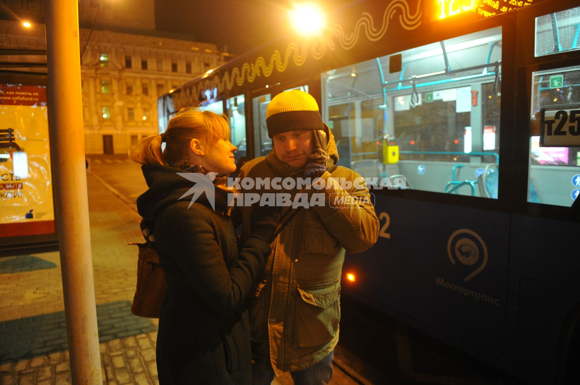 Москва. Молодой человек  с девушкой ждут автобус на остановке.